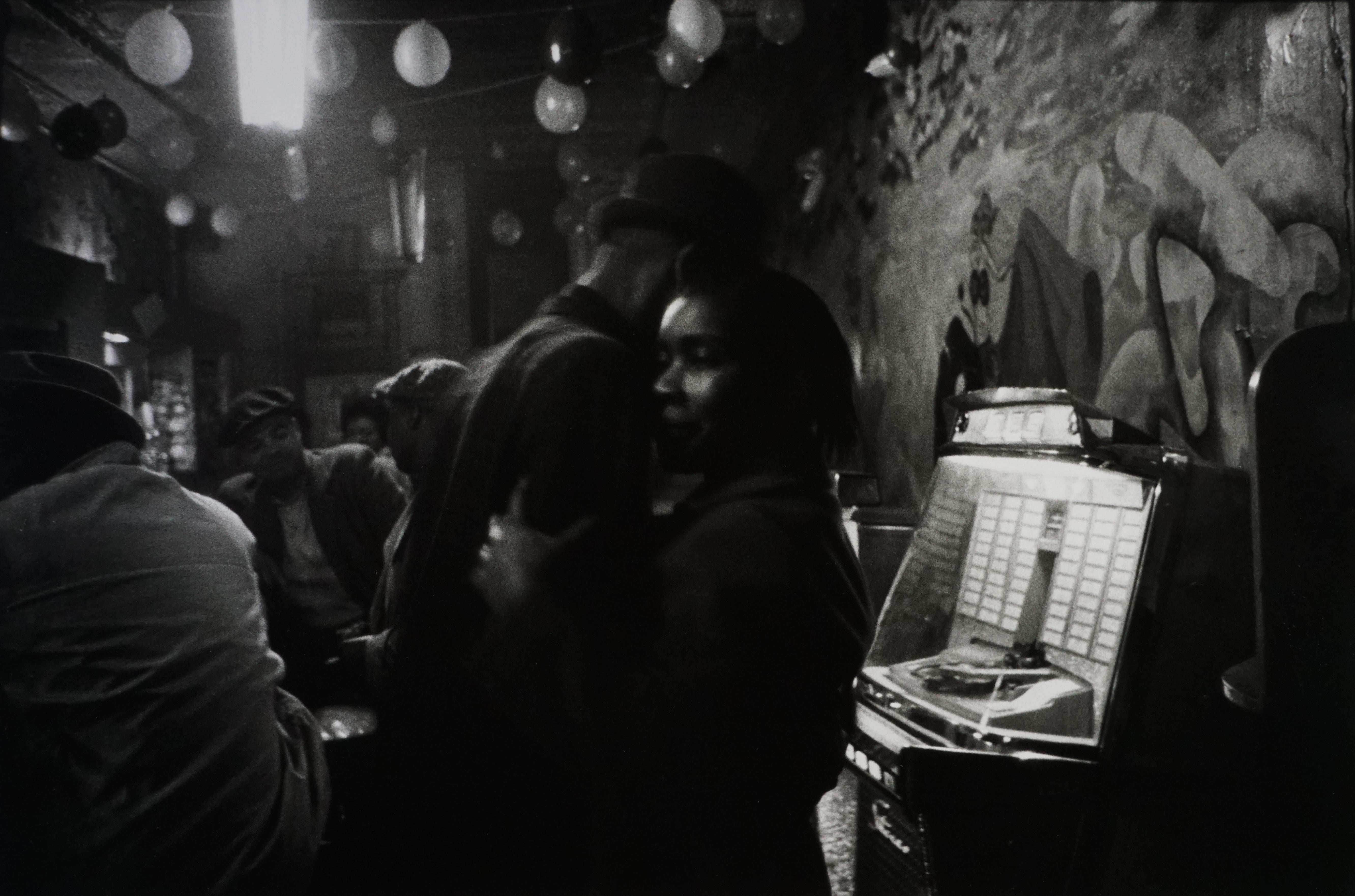 Bruce Davidson Black and White Photograph - Untitled (couple dancing by jukebox), Chicago, 1962