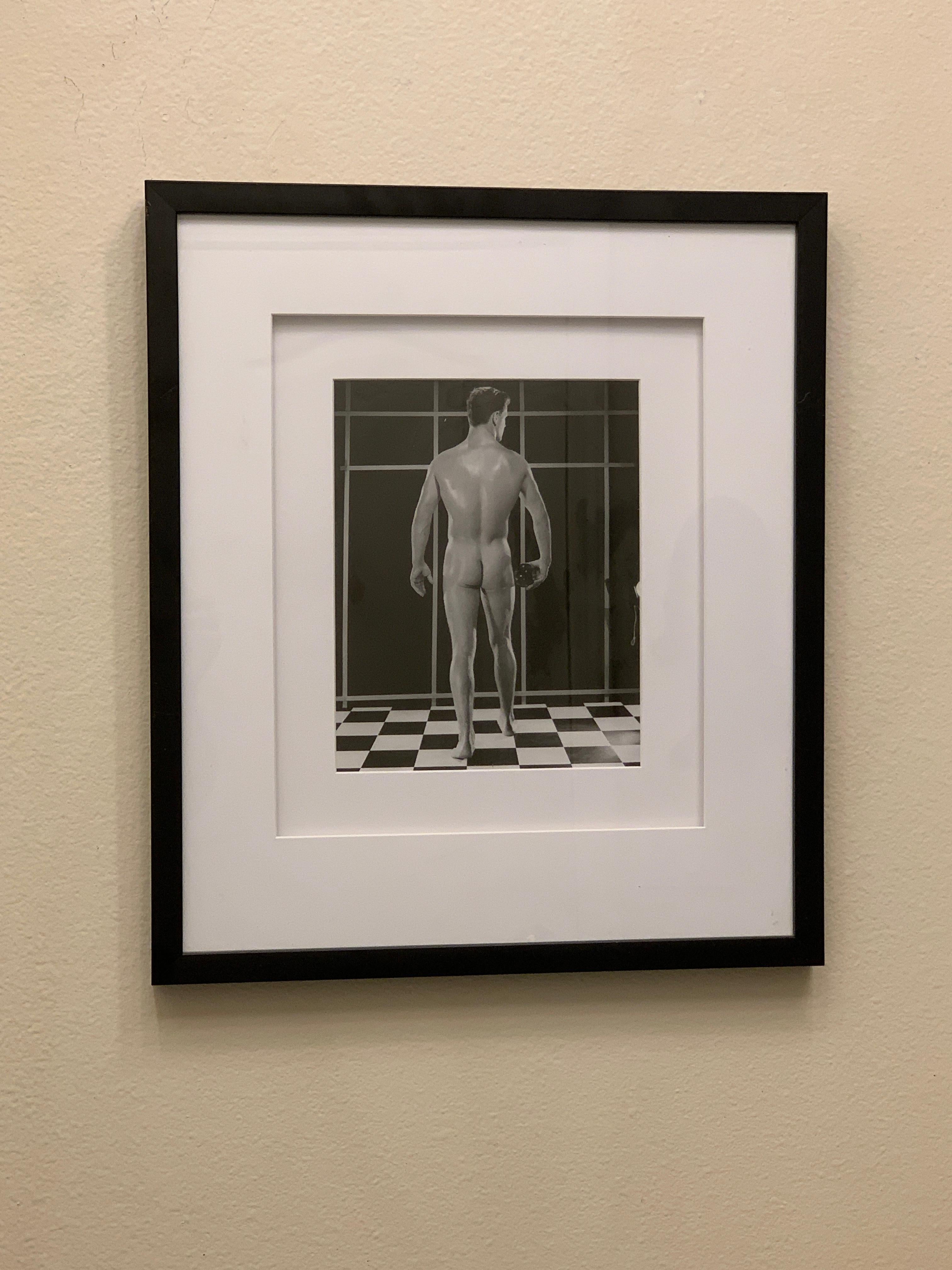 Issue d'une importante collection de plus de 25 ans de photographies de physique masculin et de Beefcake, une image emblématique réalisée par Bruce en studio avec un modèle posant sur le sol noir et blanc emblématique, montrant son dos masculin.