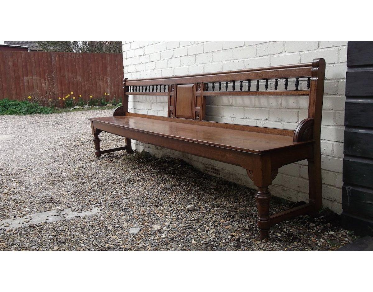 Bruce Talbert, attributed. Probably made by Gillows of Lancaster.
A good quality and long, aesthetic movement oak bench with stylized florets to the centre and a row of ebonized turnings to the top with tramline details, the sides with quarter