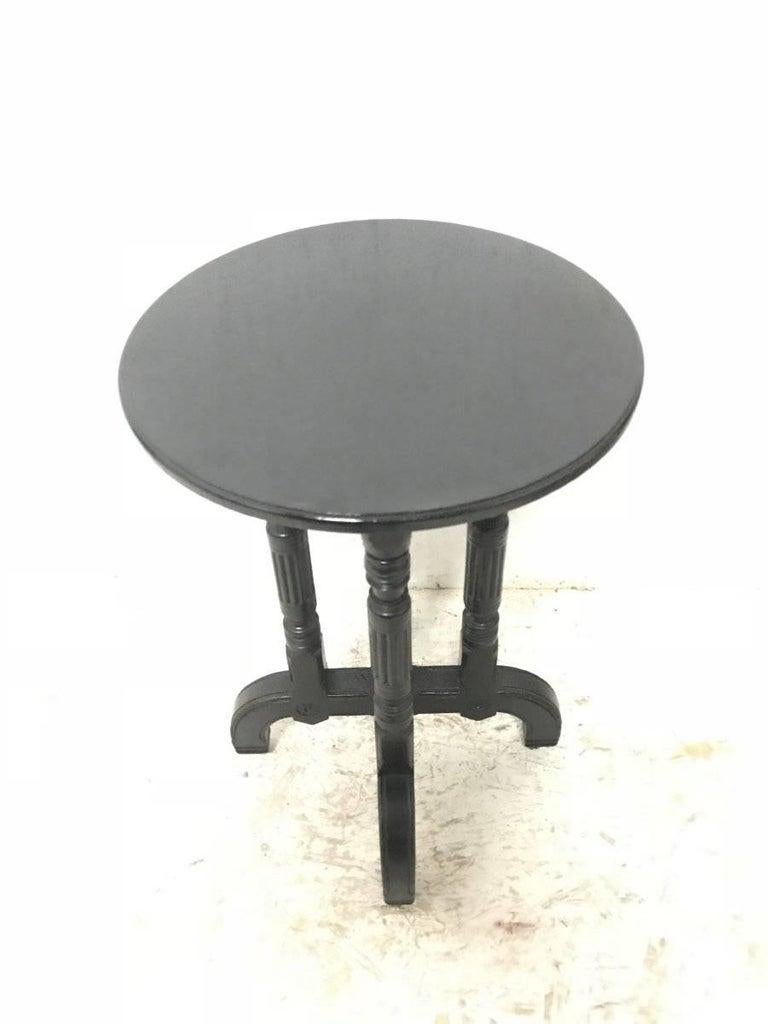 Bruce Talbert (attributed) for Gillow and Co., an Aesthetic Movement ebonized circular wine table, on four turned and fluted supports with X-base and carved florets to each side of each foot, on inset casters, stamped mark, no. 8955.