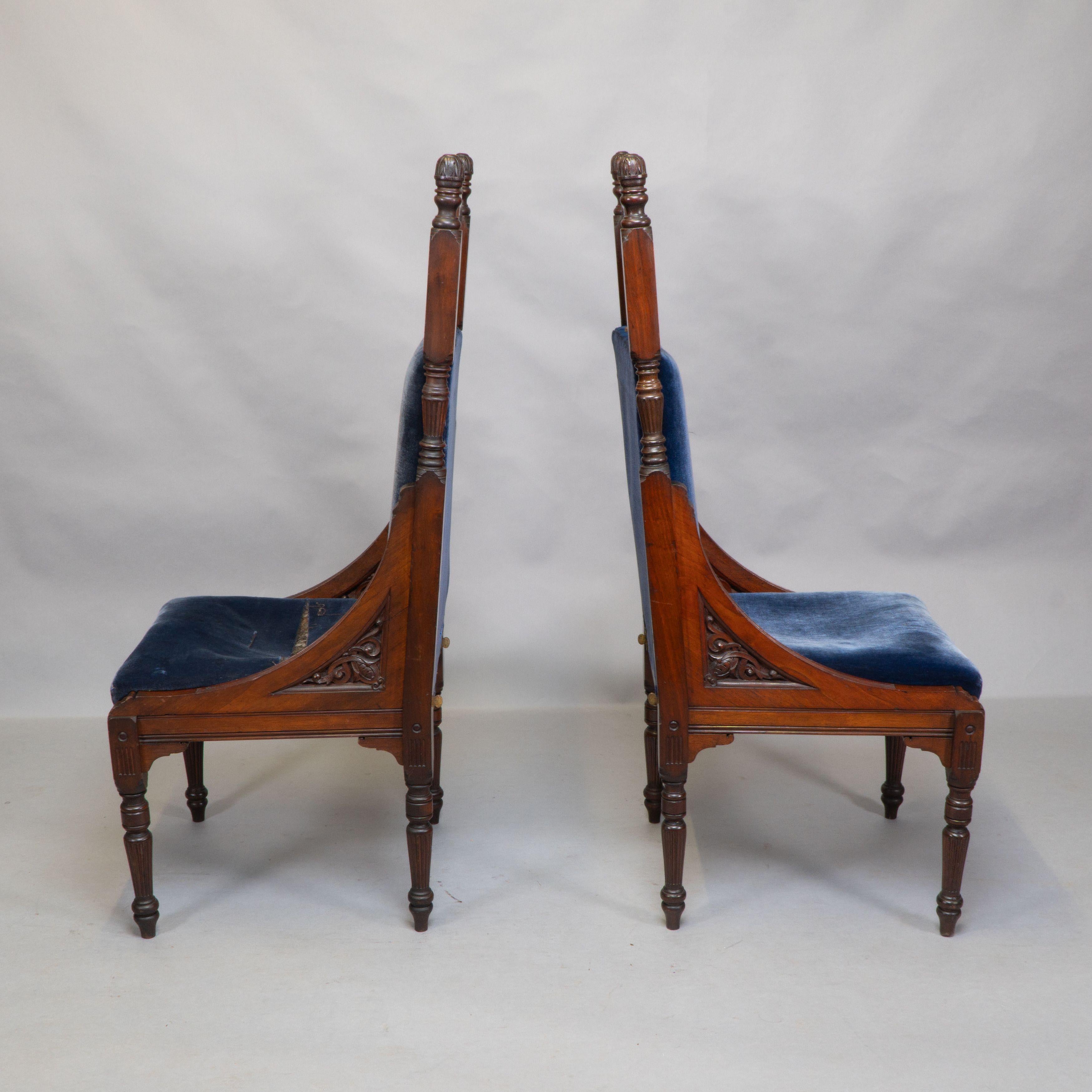 Paire de chaises à dossier haut de style trône du Mouvement esthétique, avec une fine décoration sculptée sur l'ensemble du dossier. Les sièges sont encastrables et les dossiers ont un design inhabituel : ils sont maintenus fermement en place par