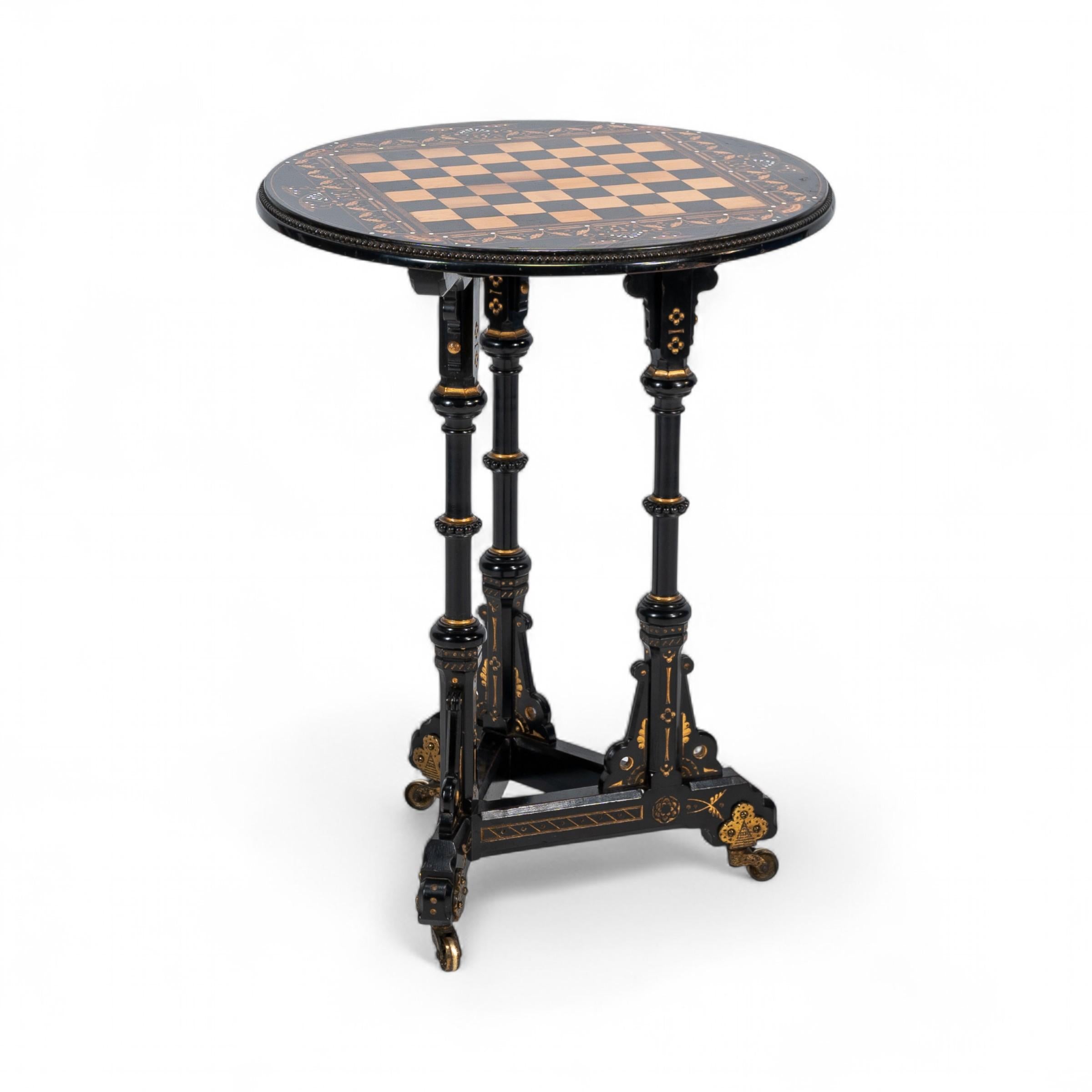 Bruce Talbert, realizzato da Gillows and Co. Eccezionale tavolo da scacchi Aesthetic Movement di qualità espositiva, con piano intarsiato in legno di bosso e tre gambe a balaustro incise e dorate con decorazioni floreali, poggiato su una base