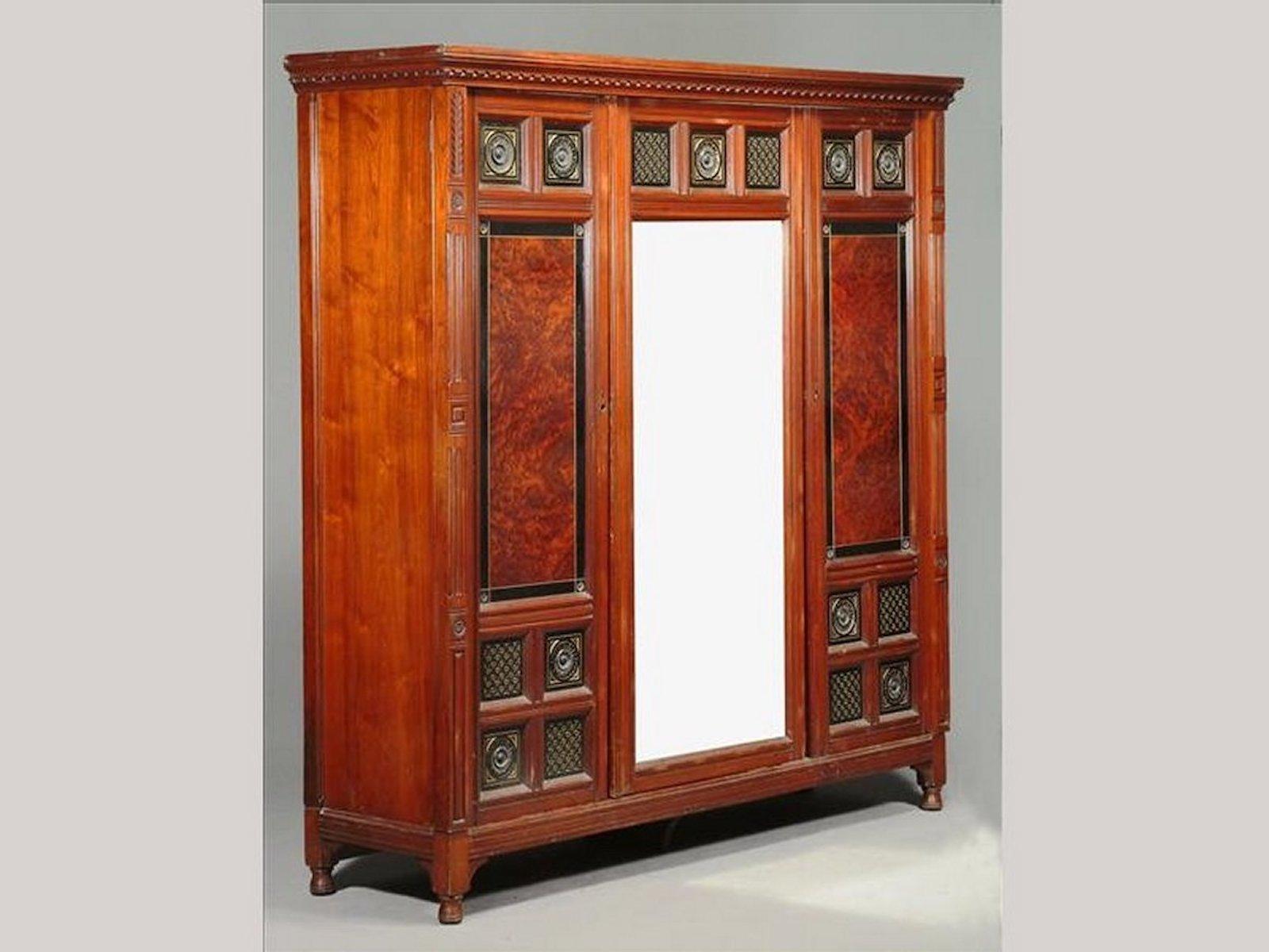Bruce Talbert (1838-1881) for Gillow and co., a rare and important walnut, amboyna, ebonized, and gilt bedroom suite, each with differing carved rosettes, comprising: a triple mirror door wardrobe, 208cm high, 208cm wide, 58cm deep; a pair of