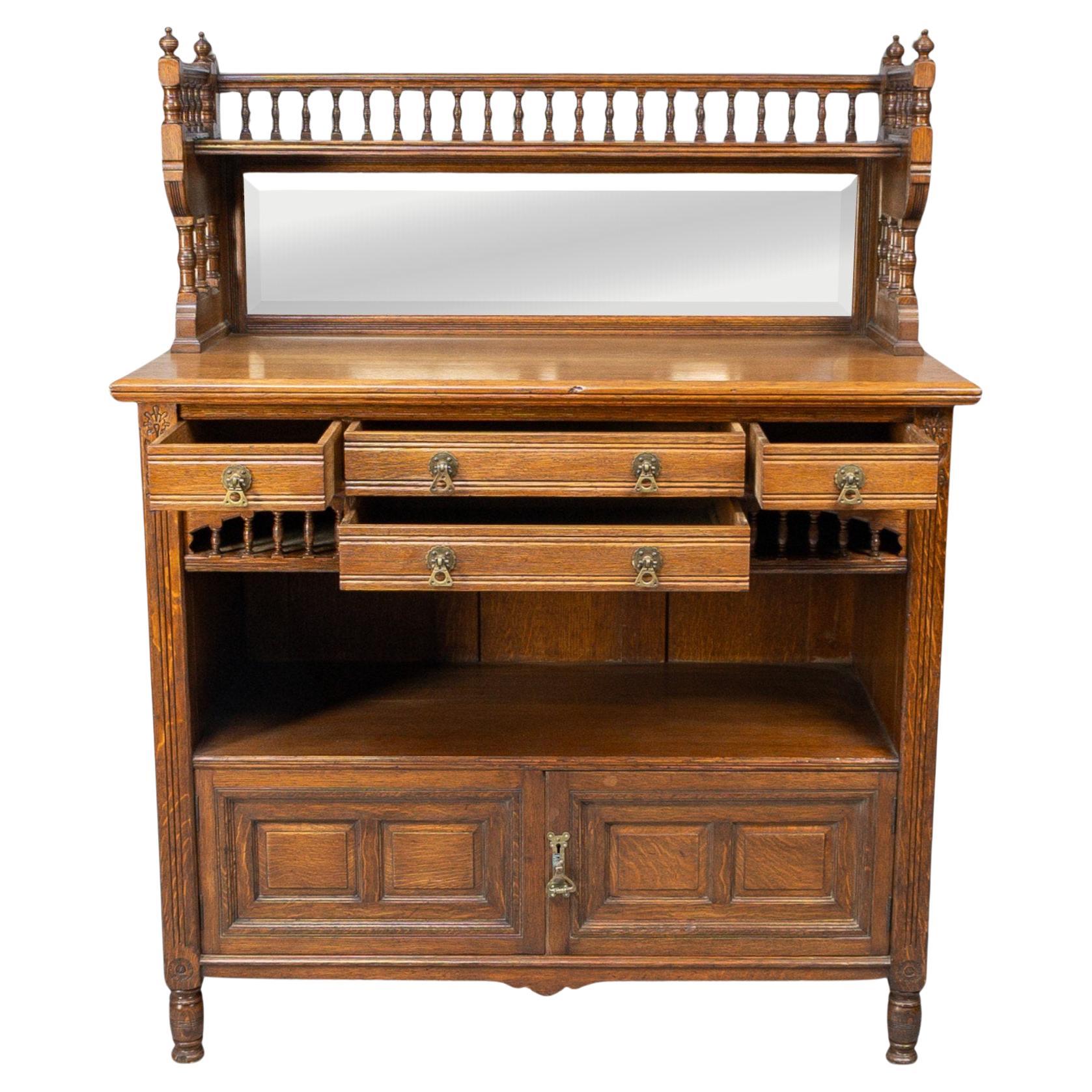 Bruce Talbert, for Gillows
An Aesthetic Movement oak sideboard with turned finials and a turned gallery above the central bevelled mirror flanked by further turnings. Four drawers with sweeping turned decoration to each lower side, an open display