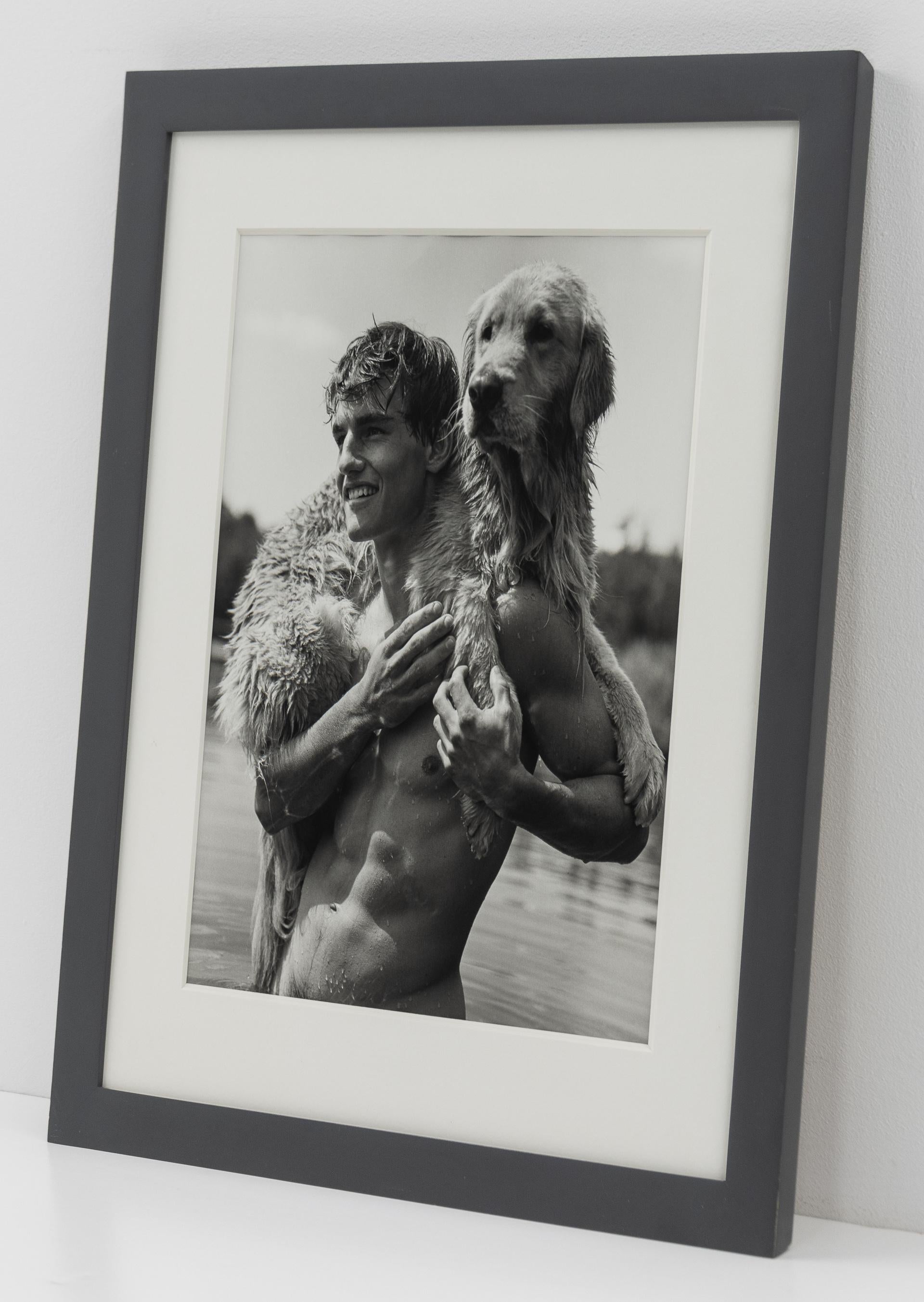 This is a Bruce Weber photograph of a smiling shirtless man and a golden retriever offered by CLAMP in New York City.