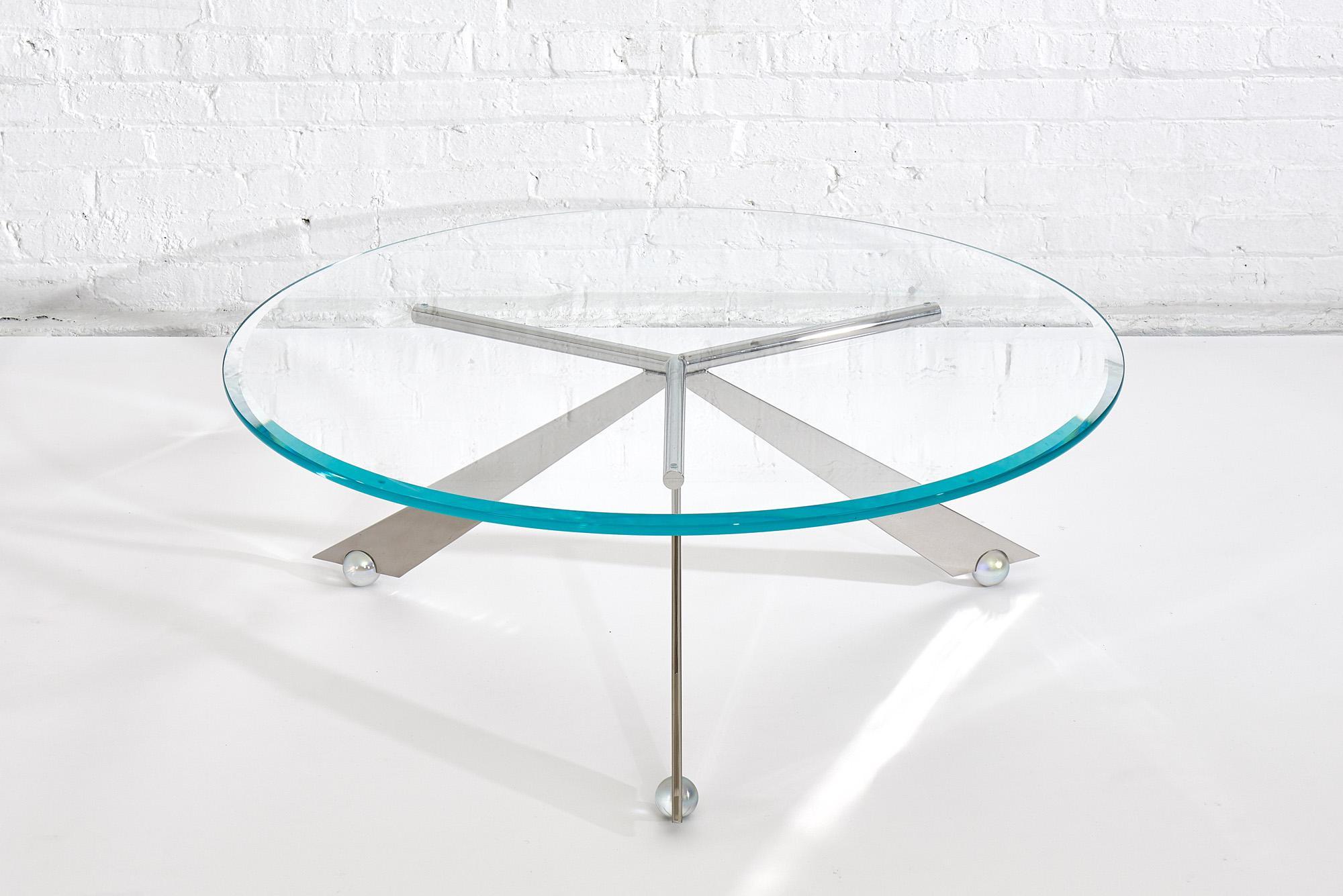Brueton Cristal stainless steel and glass coffee table by J. Wade Beam. Stainless steel base rest on glass ball feet with iridescent finish. Glass has a faceted edge.