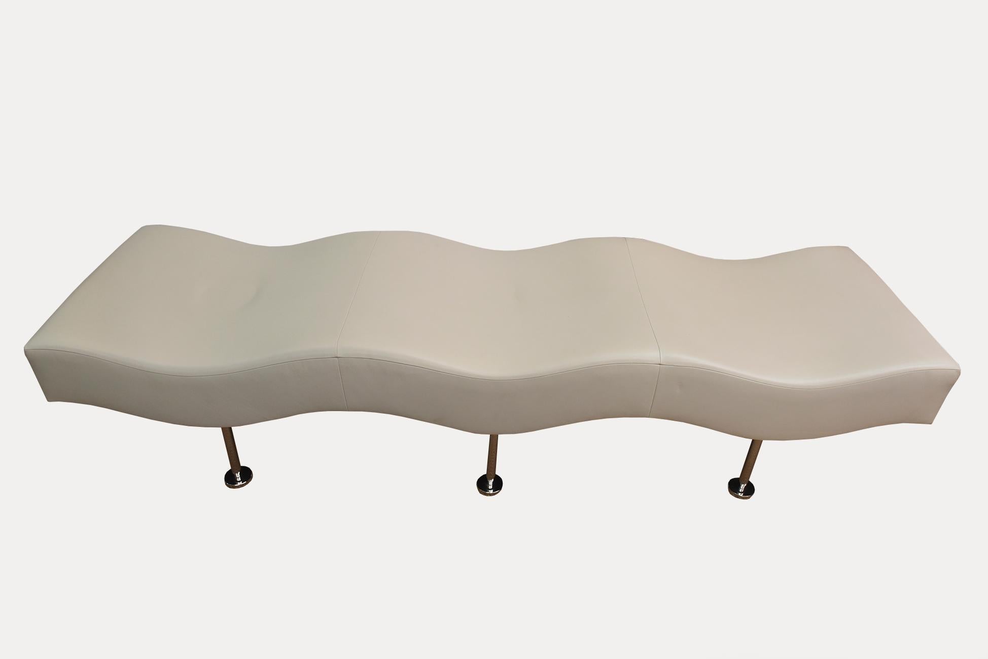 This long and 3 seat wave chaise sculptural bench was designed by Stanley Jay Friedman for Brueton in the 1980s. It has been coined the undulatus bench as in waves. There is a feeling of momentum. It has the original light tan leather on it and