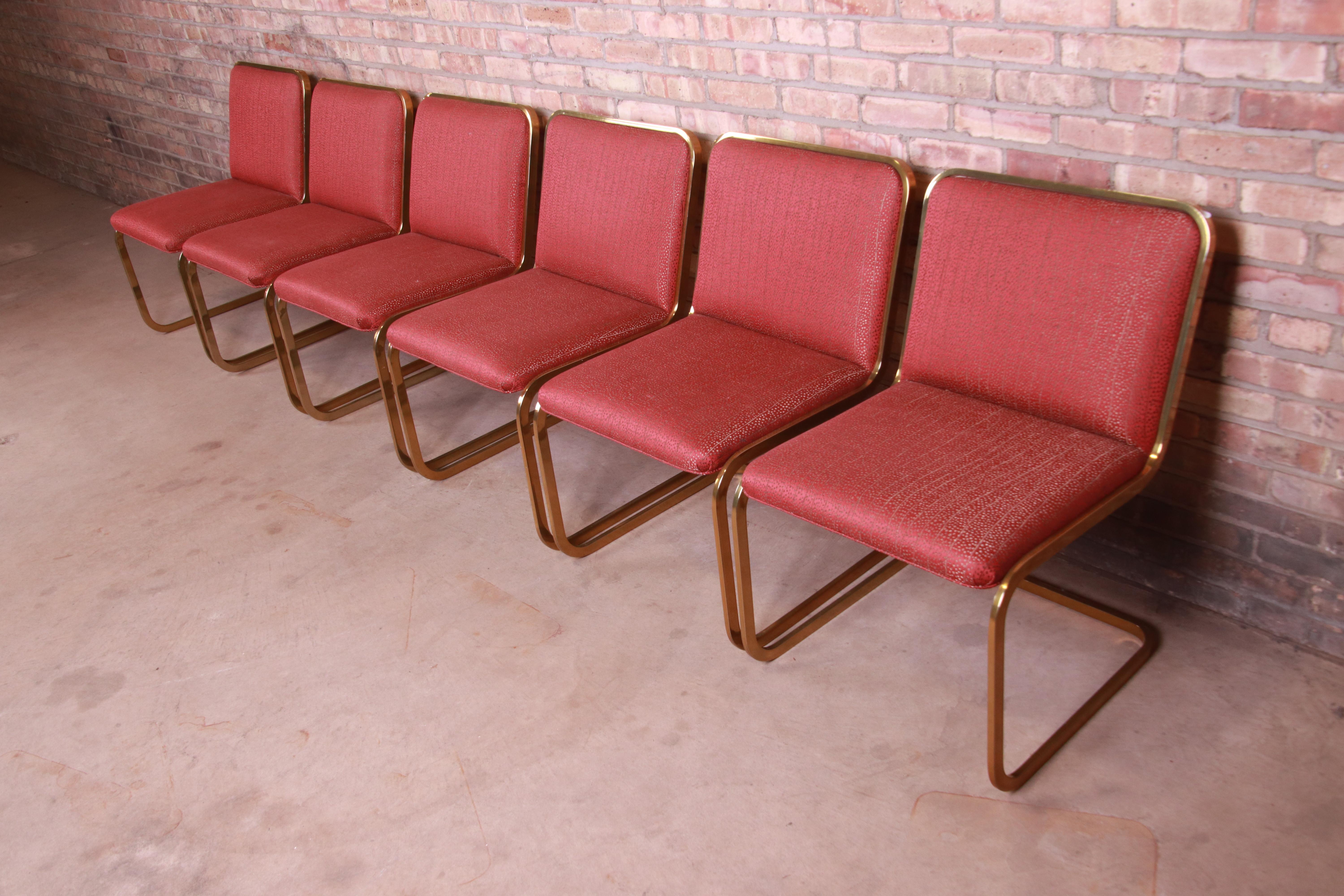 A gorgeous set of six Mid-Century Modern Hollywood Regency dining chairs

In the manner of Milo Baughman

By Brueton

USA, 1970s

Cantilevered brass frames, with stylish red and gold upholstery.

Measures: 21