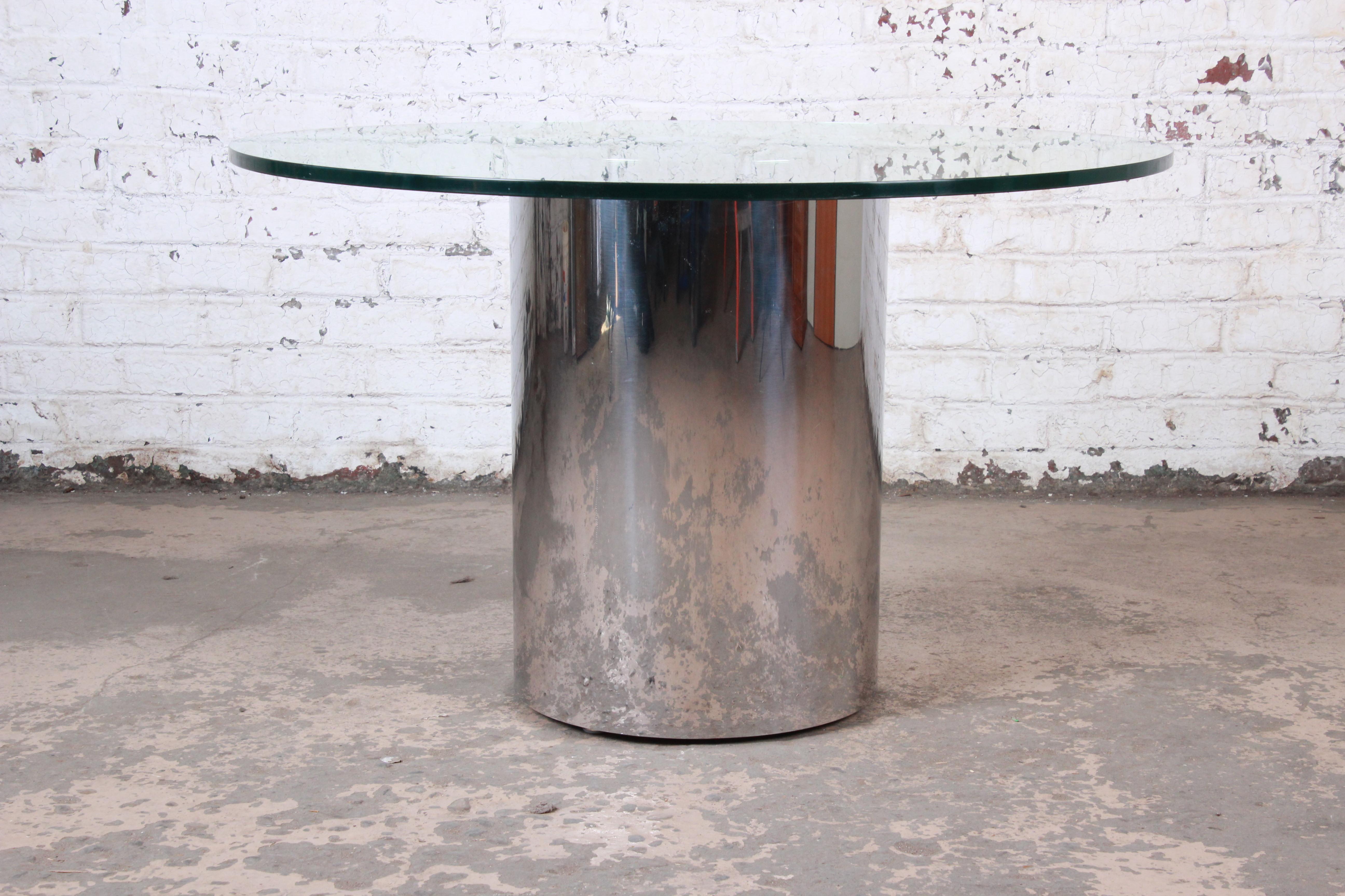 A sleek and stylish Mid-Century Modern drum base pedestal dining or center table

By Brueton

USA, circa 1970s

Polished steel base and thick glass tabletop

Measures: 48