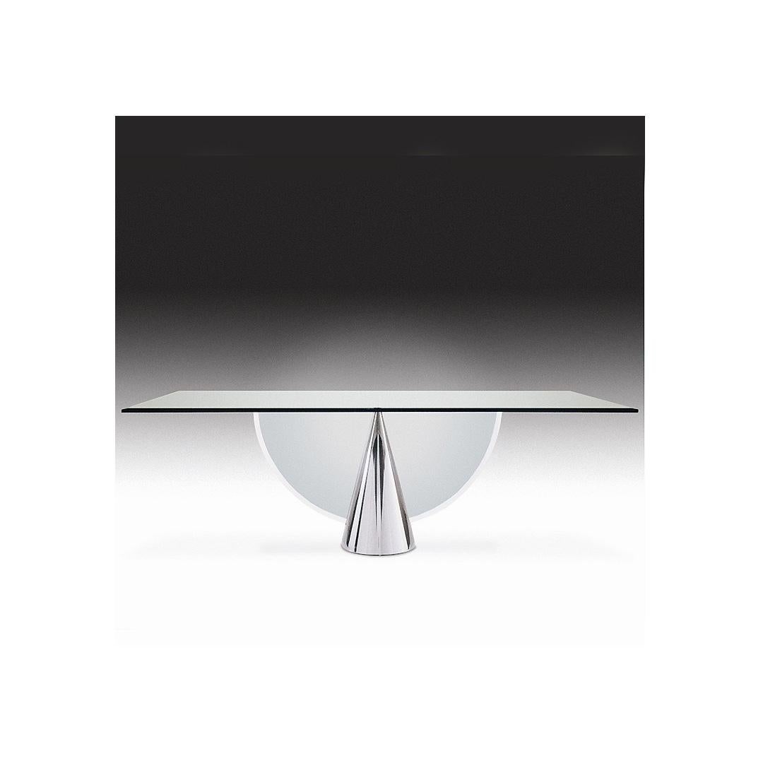 Audacieuse et sophistiquée, cette table primée atteint les sommets de l'expression minimaliste. Une forme conique en métal, visuellement solide, est coupée en deux par un demi-cercle de verre pour former une base innovante et contrastée sur laquelle