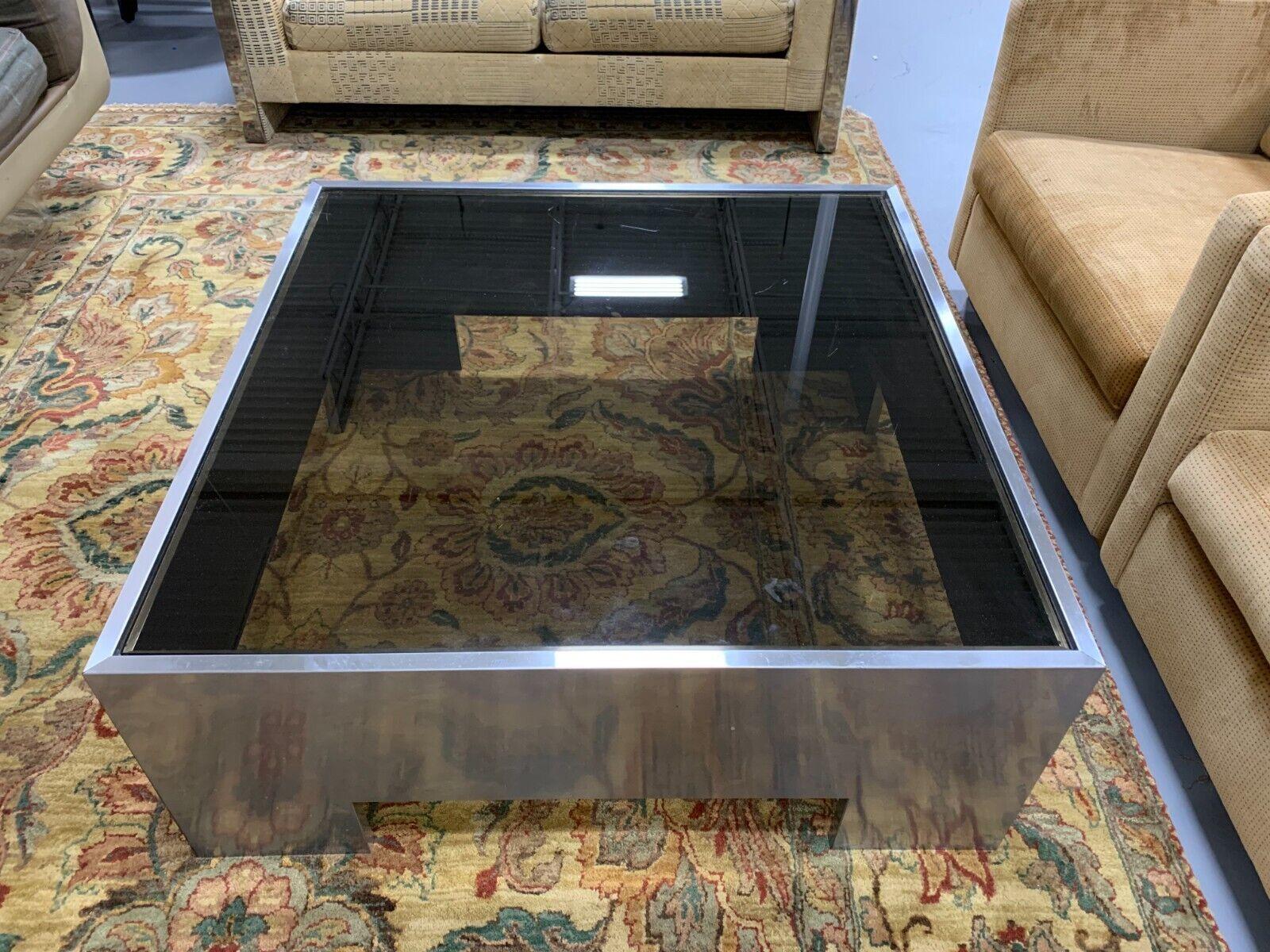 Le Shoppe Too presents this amazing and very sturdy smoked glass with a stainless steel base square coffee table attributed John Mascheroni. In good condition.
Dimensions: 15
