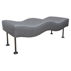 Banc Brueton Undulatus tapissé de tissu bouclé gris argenté avec pieds en acier inoxydable