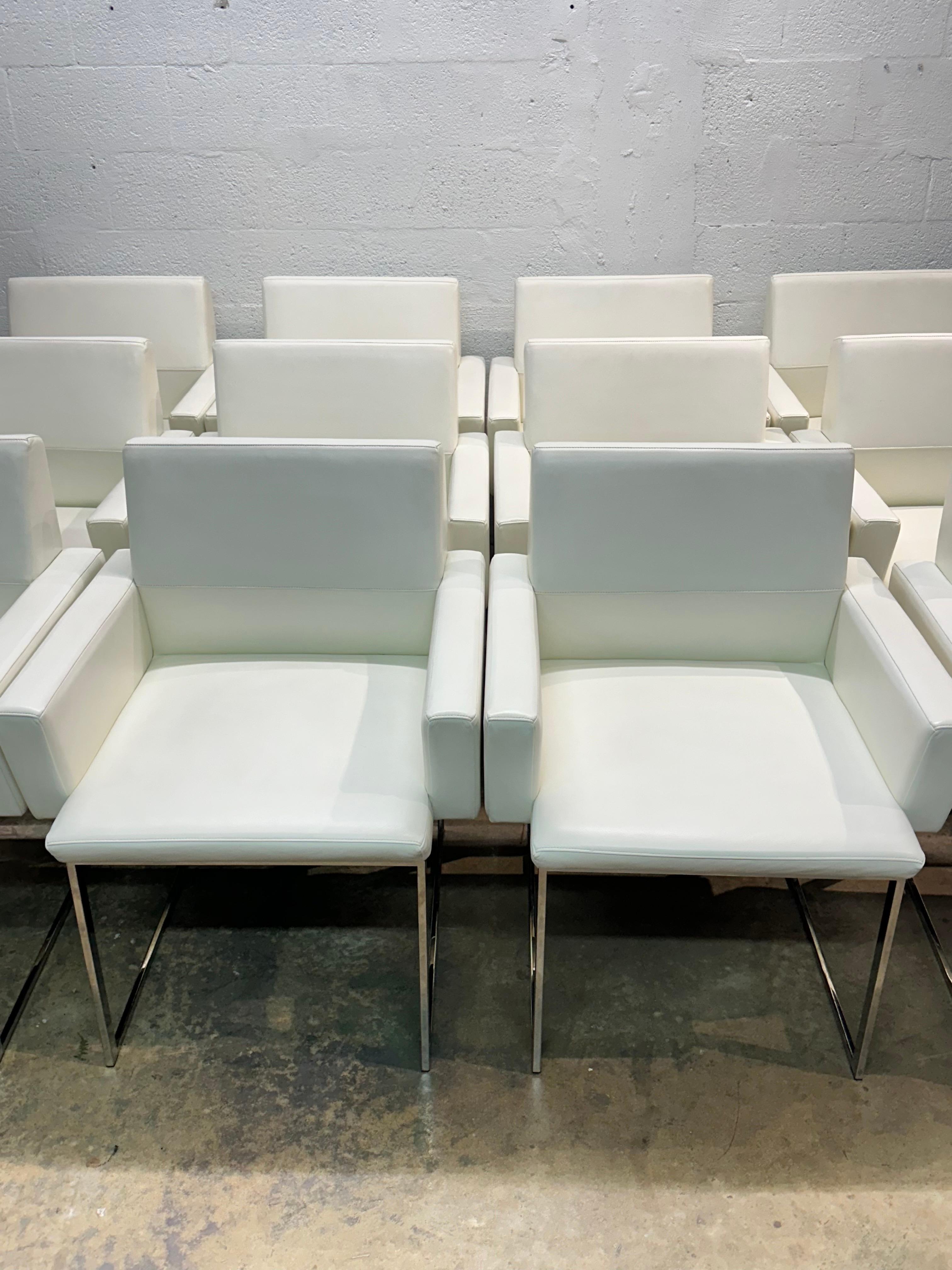 Bright white Naugahyde eco-leather dinging arm chairs on polished chrome bases by Brueton International.

Price is per pair of chairs.  Only five pairs available.  (One pair has sold)

Arm Height: 24-1/2”