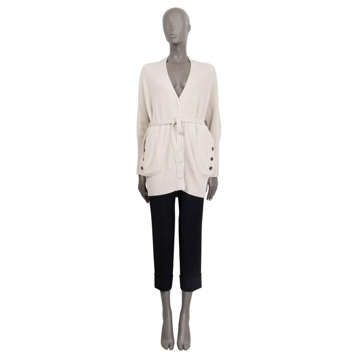 100% authentic Brunello Cucinelli belted knit cardigan in beige cotton (100%). Features buttoned sleves with metal pearl embellishment and buttoned pockets on the front. Opens with one concealed button on the front. Unlined. Has been worn and is in