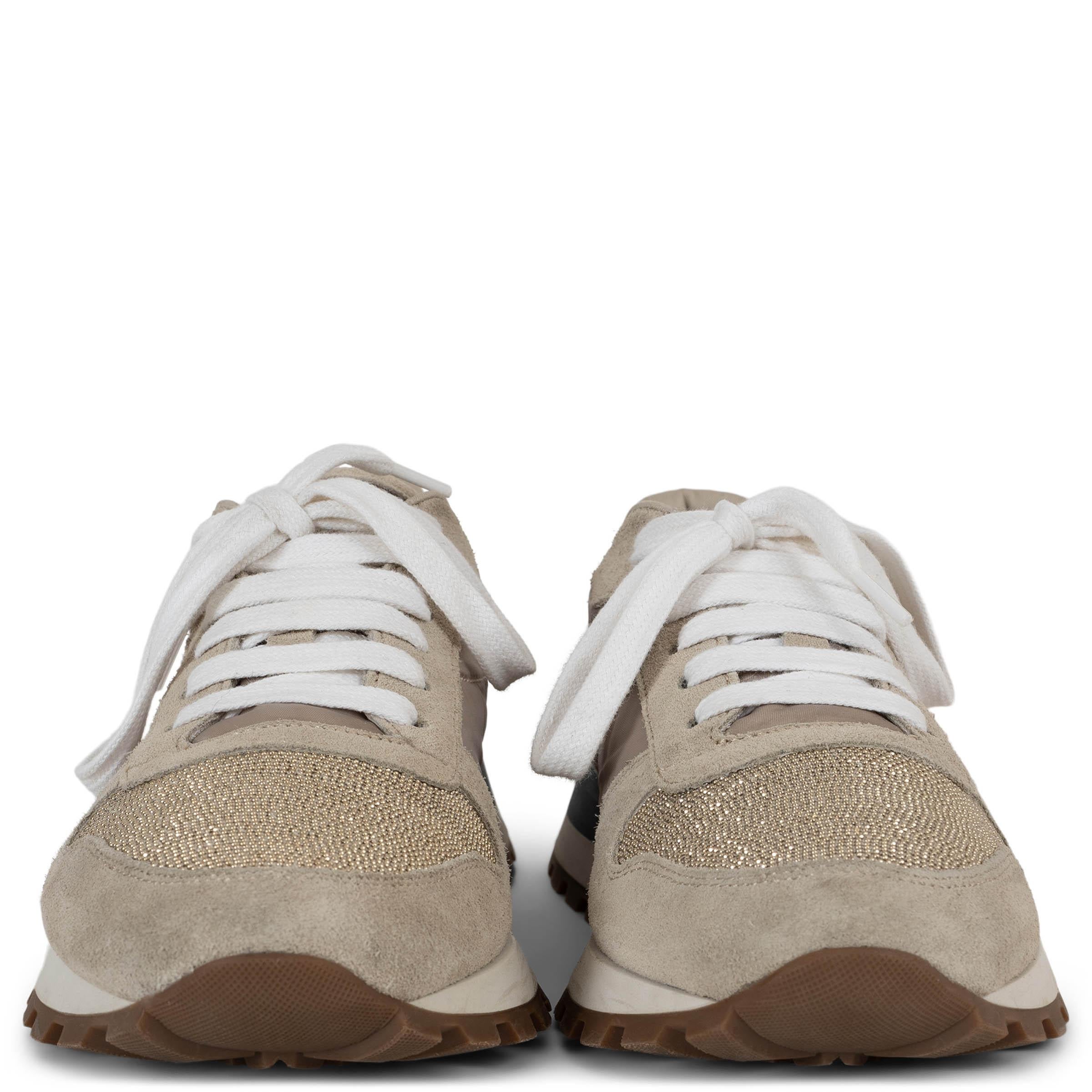 Estas zapatillas bajas 100% auténticas de Brunello Cucinelli en nailon arena irradian un lujo discreto con un toque deportivo. Acentuados con adornos de ante color arena, presentan puntera redondeada y una parte superior con el característico adorno