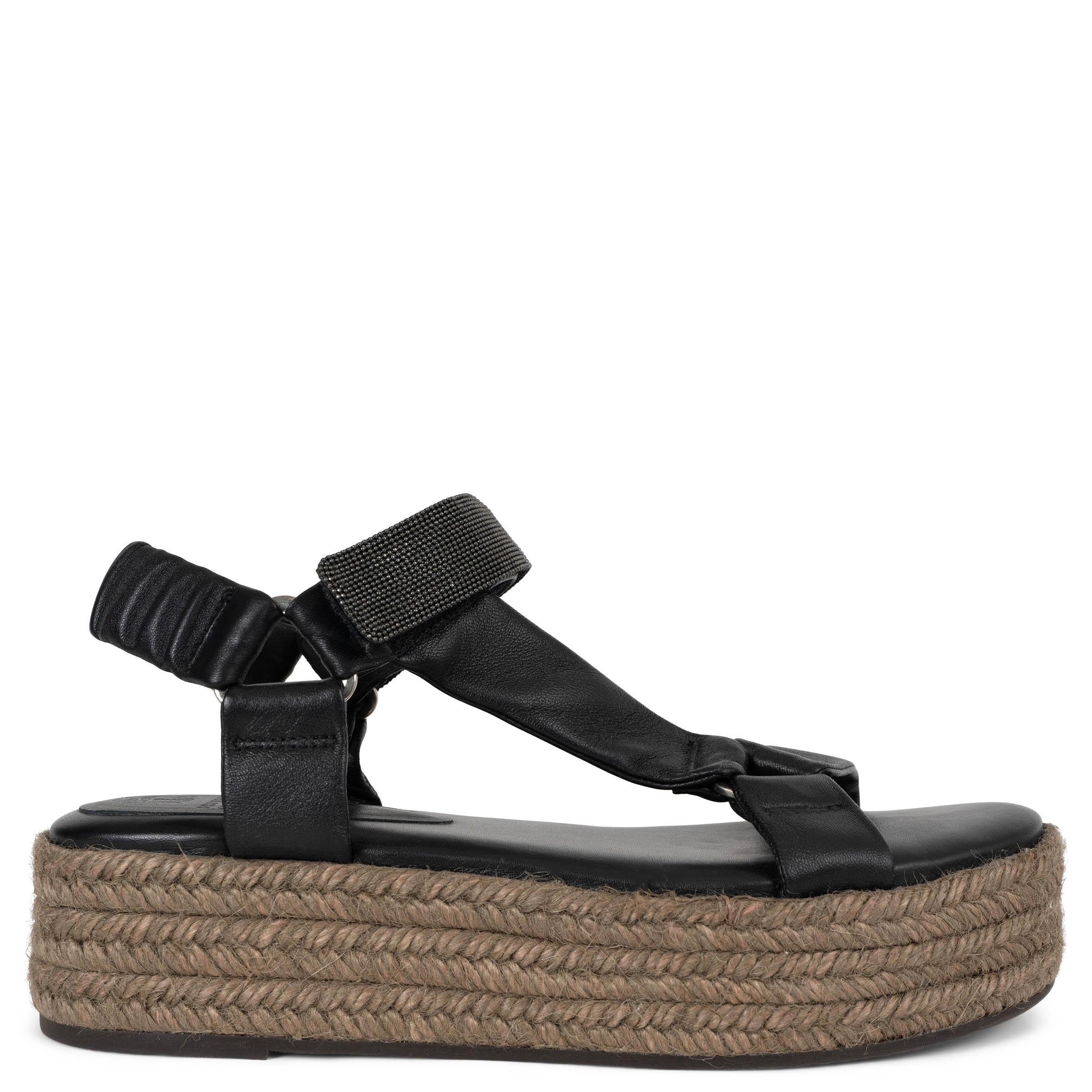 Diese 100% authentischen Brunello Cucinelli Sandalen aus schwarzem Lammleder verbinden raffinierte Details mit lässiger Eleganz. Sie haben ein asymmetrisches T-Riemchen und sind mit der markentypischen Monili-Verzierung verziert, die für einen Hauch