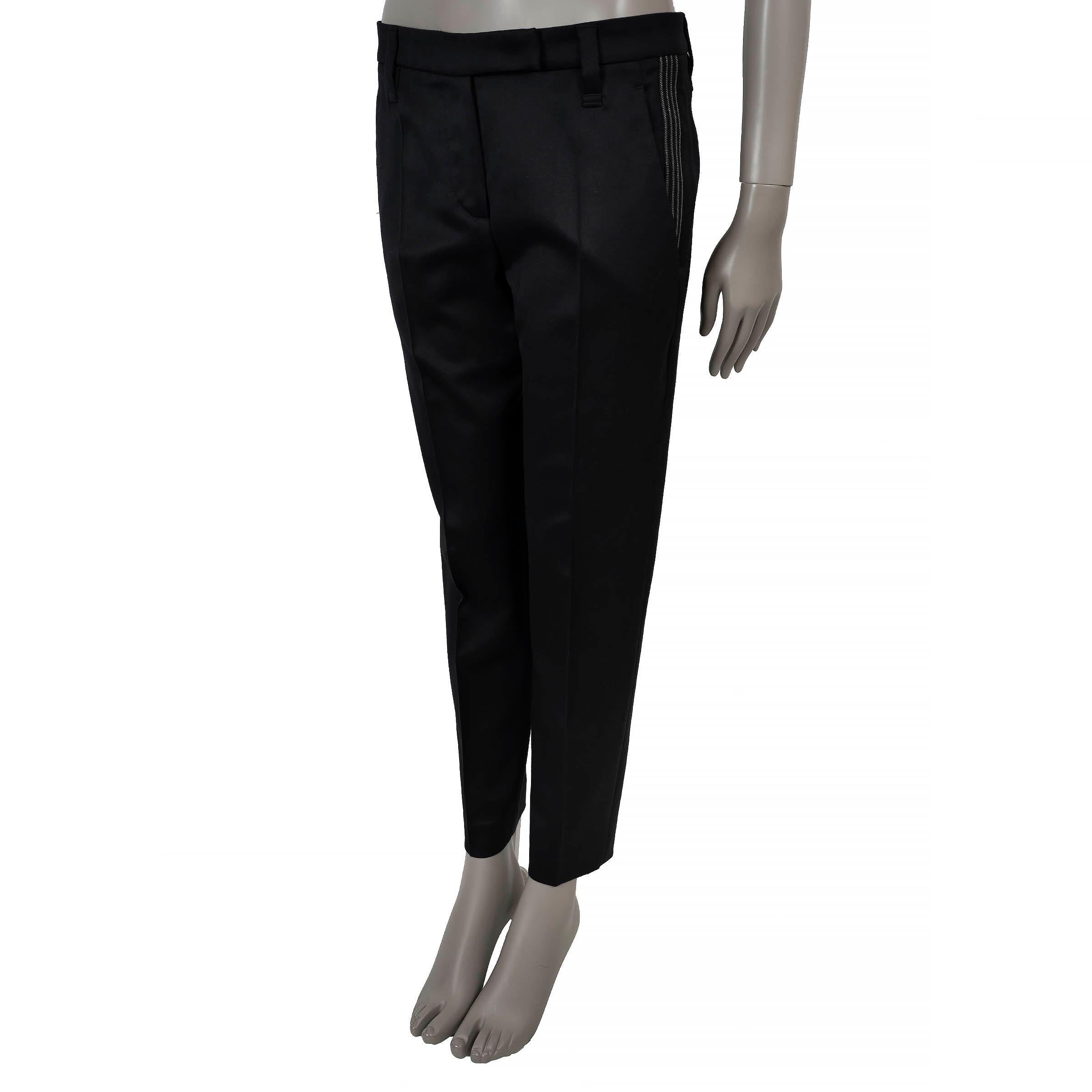 Ce pantalon de smoking 100% authentique Brunello Cucinelli est taillé dans une laine satinée noire avec une touche d'élasthanne (2%) pour faciliter les mouvements. Il présente une silhouette fuselée, des plis nets sur le devant et une bande de