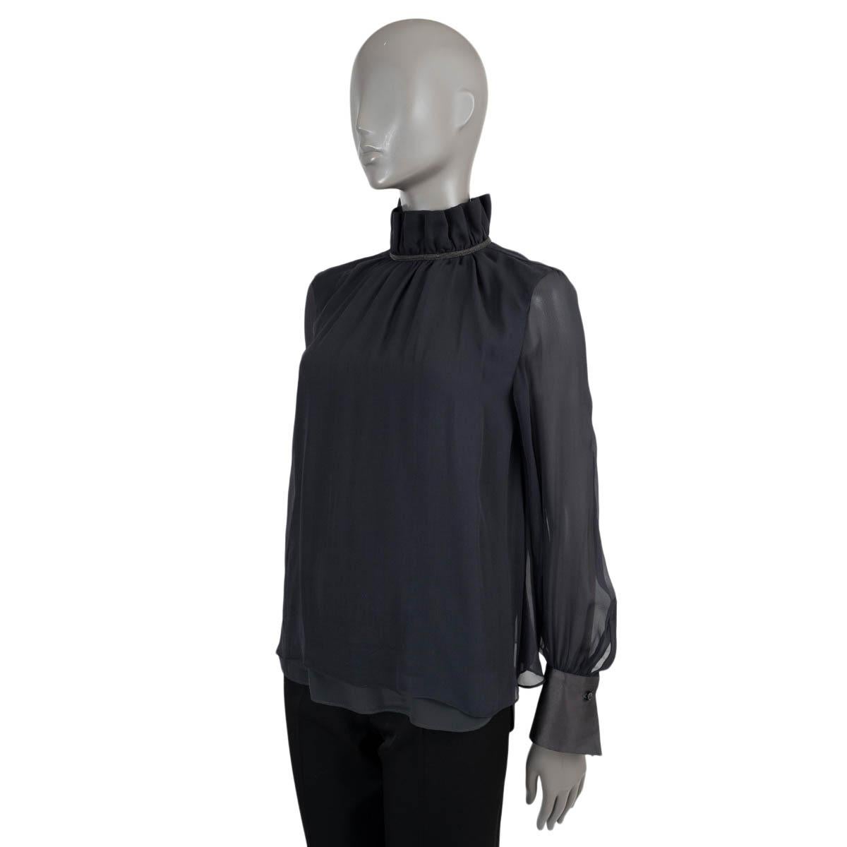 100% authentic Brunello Cucinelli layered chiffon blouse in black silk (100%). Features a ruffled high neck with Monili trim, body layered with slightly longer satin and buttoned satin cuffs. Opens with a button in the back. Has been worn and is in