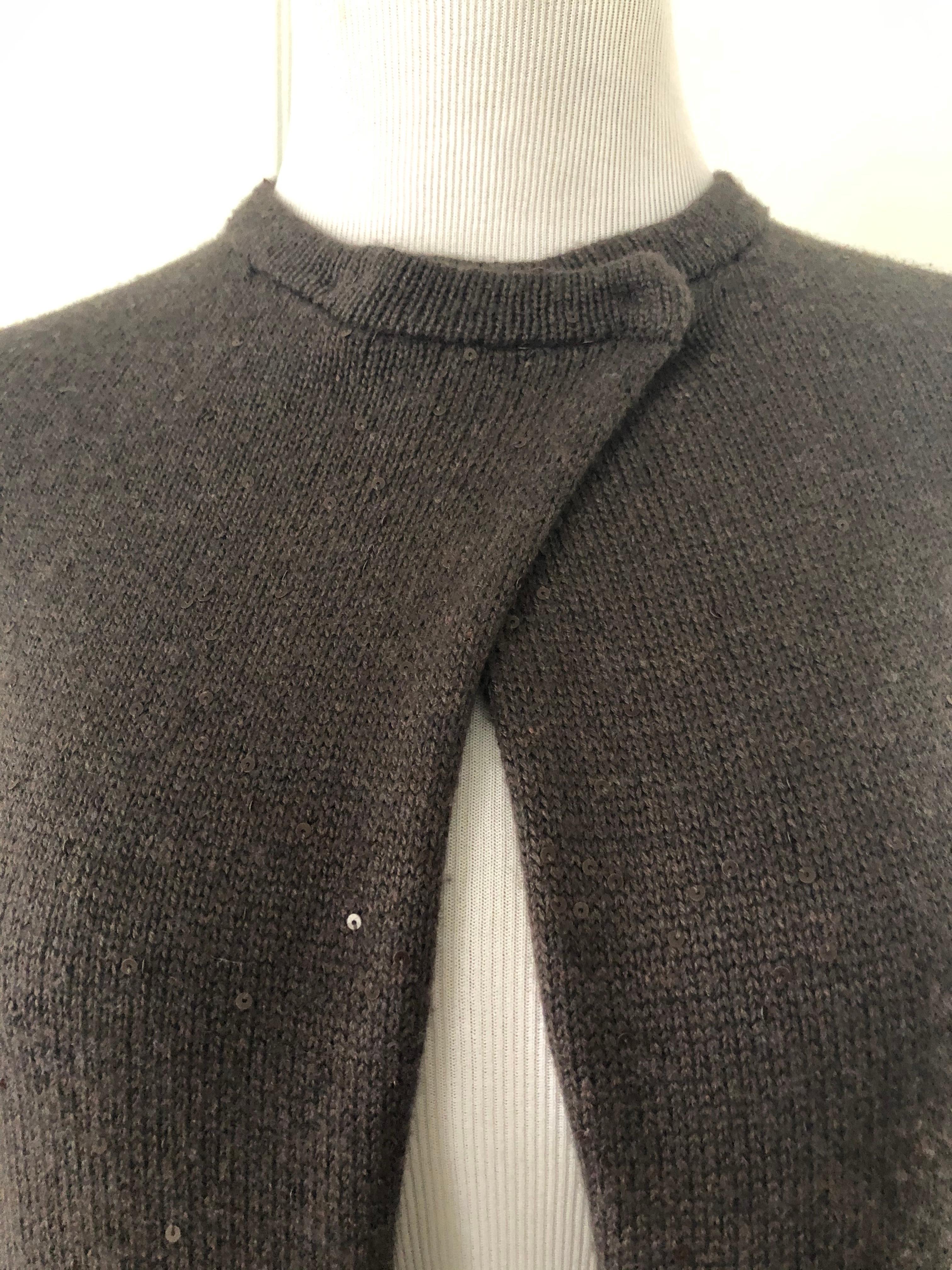 This is a lovely knit cashmere cape sweater with 2 openings for arms with snap closure at the neck.
Discreet sequence all over  the knit. Very good condition.Will keep you warm with a touch of class.
Length     23