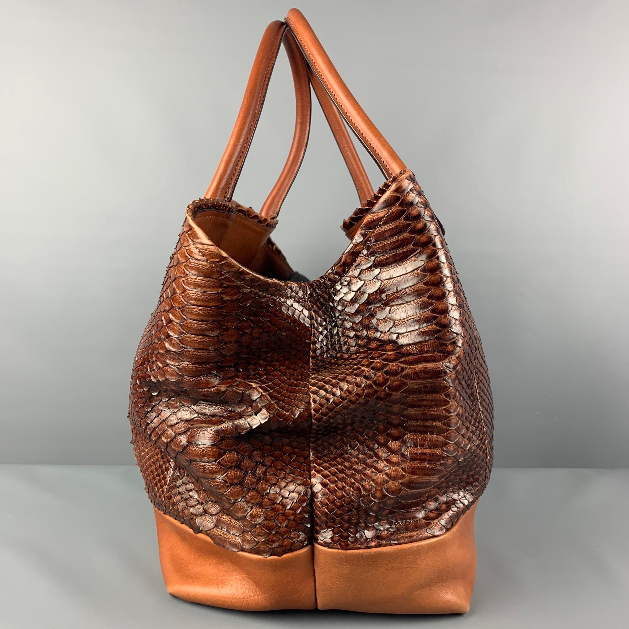 BRUNELLO CUCINELLI tote comes in a cognac embossed calfskin featuring top handles, gray flannel interior, dual compartment, open top, and a inner zipper closure. Made in Italy. 

Very Good Pre-Owned Condition.

Measurements:

Length: 11.5 in.
Width: