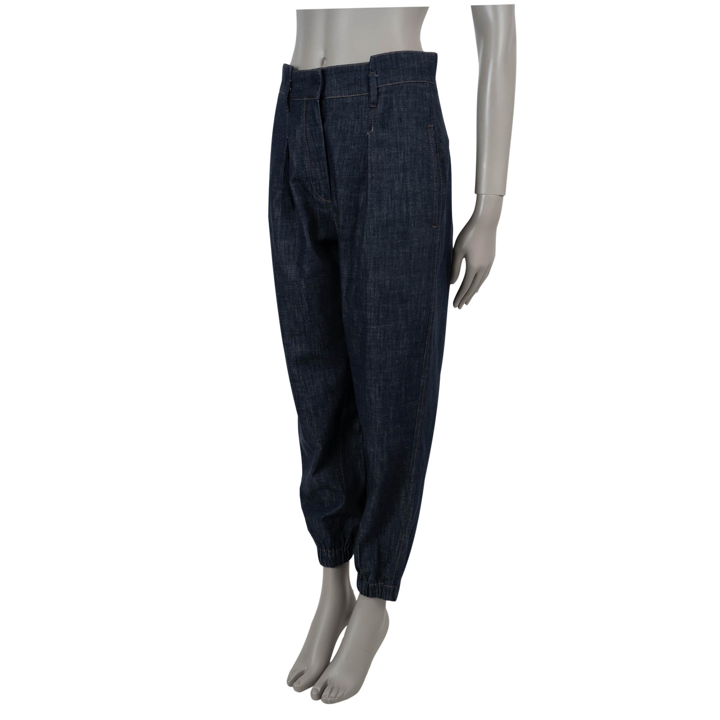 This 100% authentic Brunello Cucinelli jogger pants in dark blue denim cotton redefine casual luxury with impeccable craftsmanship. Designed with a relaxed silhouette and elastic cuffs, they offer effortless elegance and comfort. Featuring two slant