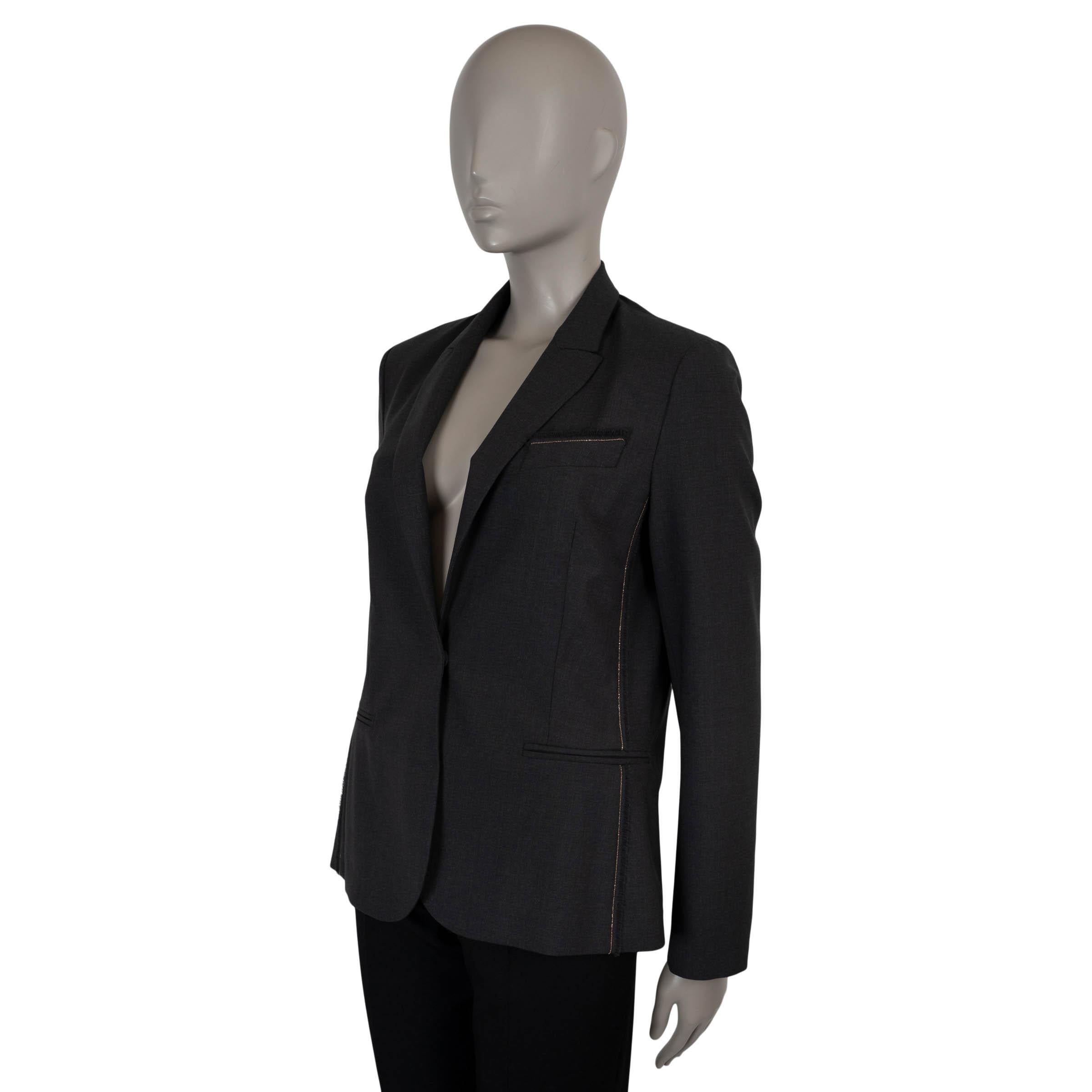 Questo blazer di Brunello Cucinelli, autentico al 100%, è realizzato in lana leggera grigio antracite (75%), poliammide (23%) ed elastan (2%), per unire struttura e facilità di movimento. Presenta una silhouette aderente con revers a lancia, una