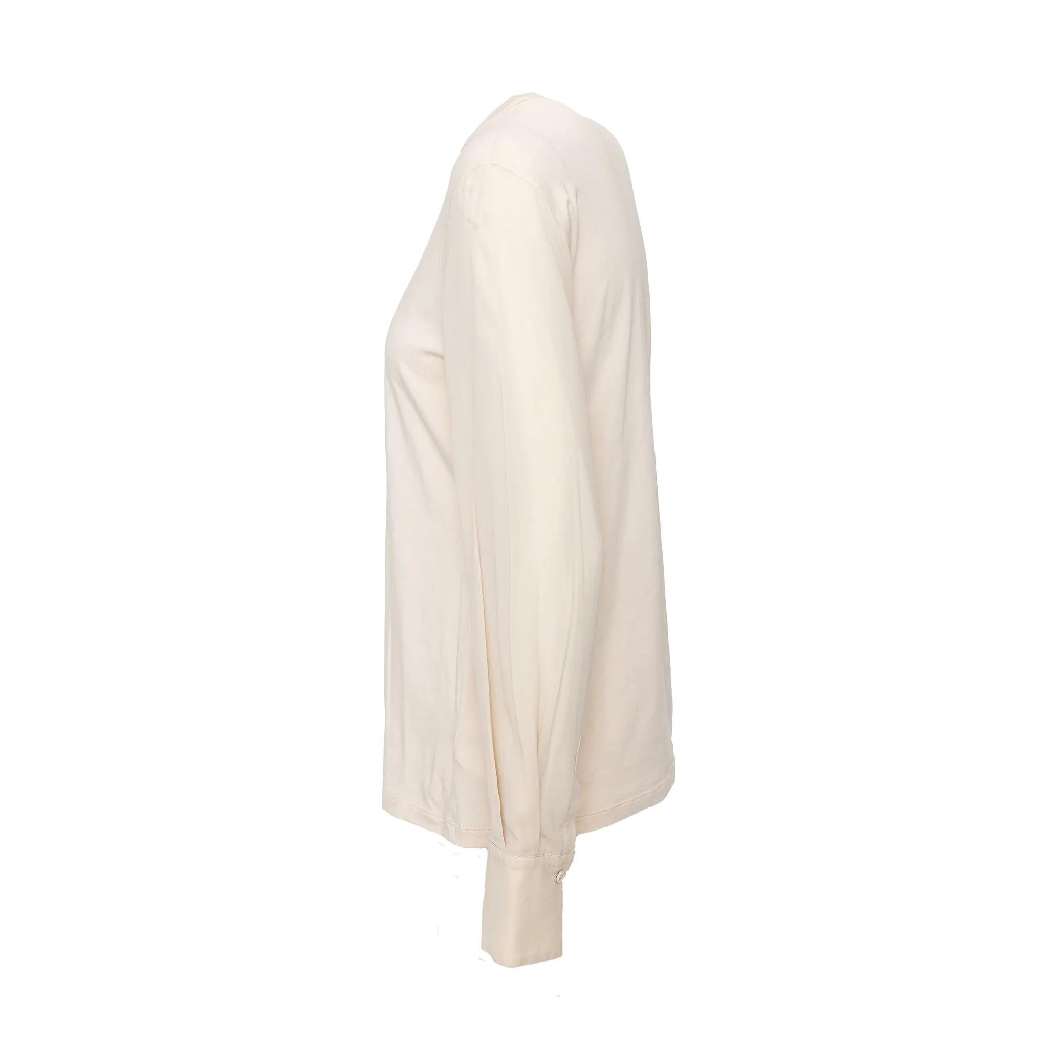 Top Brunello Cucinelli in misto cotone bianco panna. Presenta uno scollo a V arrotondato e maniche con polsini in misto seta per un look casual ma elevato. 
 Materiale: 93% cotone 7% elastan