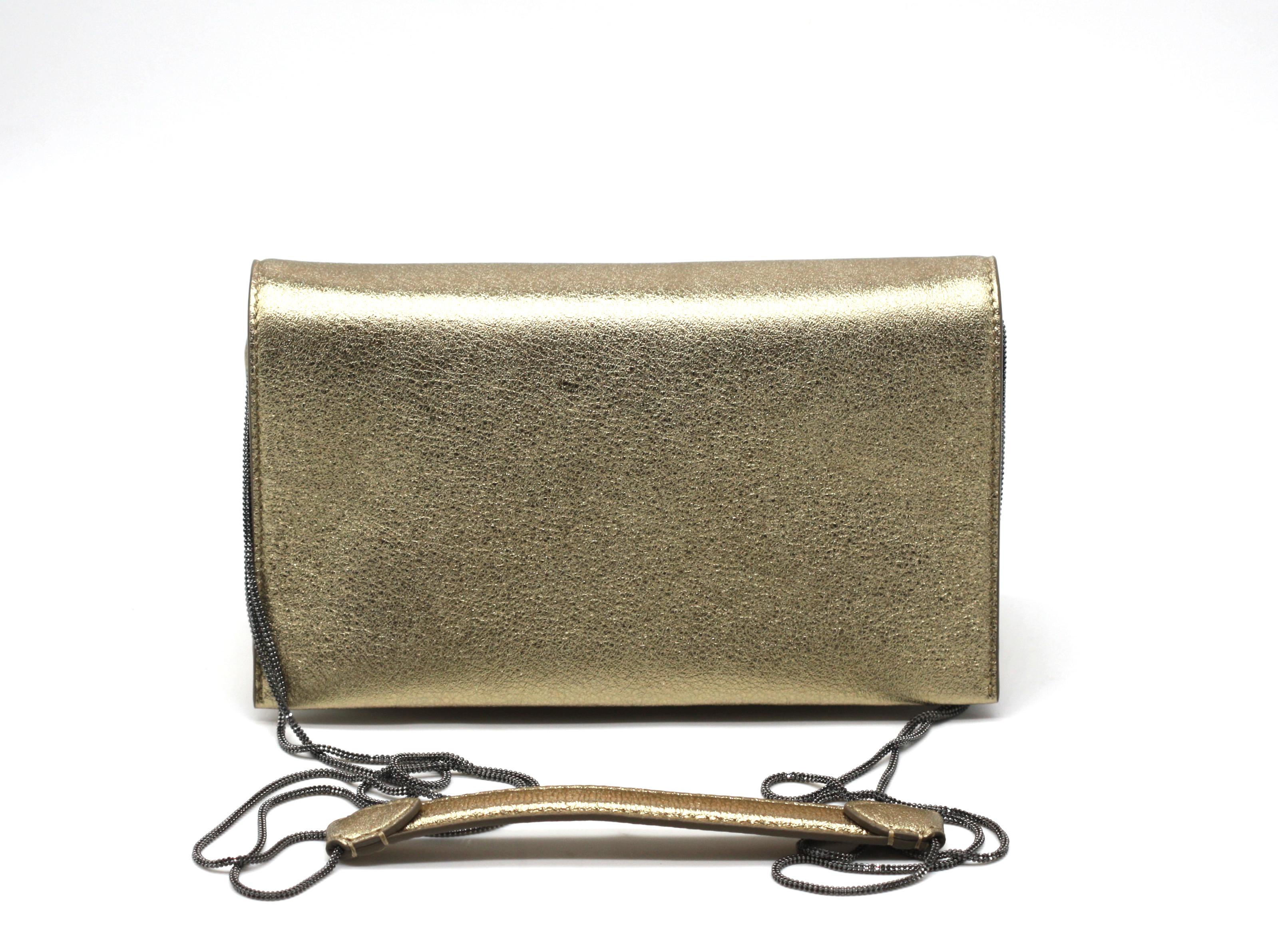 
Brunello Cucinelli Gold Leather Evening Clutch
With retail tag, appears new and never used. Rectangular with a magnetic flap, the divided interior with a small slit pocket, with a 6.5 inch leather strap connected to black-toned long shoulder