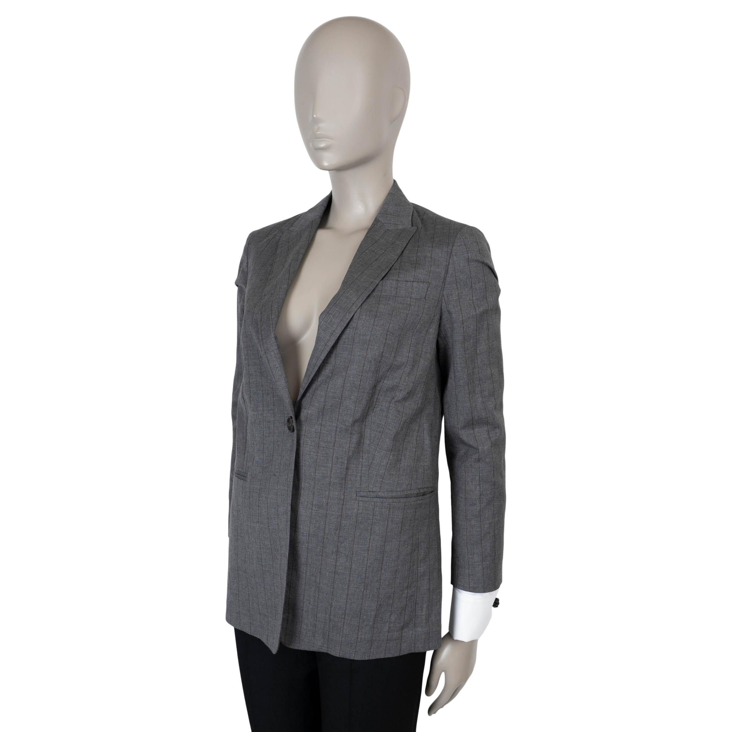 Questo blazer 100% autentico di Brunello Cucinelli è realizzato in lana grigio scuro (54%) e lino (46%) con raffinati gessati. Presenta una silhouette sartoriale con revers a lancia, una tasca sul petto e due tasche a fessura sul davanti. Le maniche