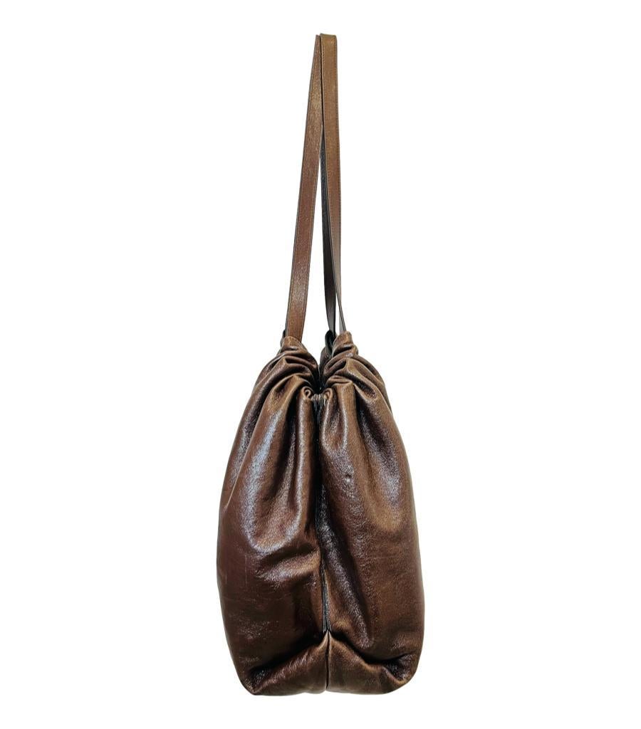 Brunello Cucinelli Leather Tote Bag

Dark brown tote bag accented with silver logo lettering to the front.

Featuring drawstring detailed dual shoulder strap and top snap closure leading to spacious interior with zipped pocket.

Size – Height 37cm,