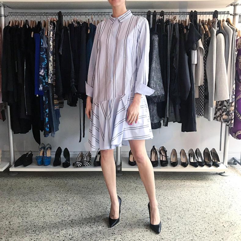 Brunello Cucinelli Light Blue Cotton Striped Shirt Dress.  Original retail $1750 USD. Straight cut body with buttons down front, dropped waistline with asymmetrical hem pleated skirt, ivory and black sequin stripes.  Marked size L (fits size USA 8).