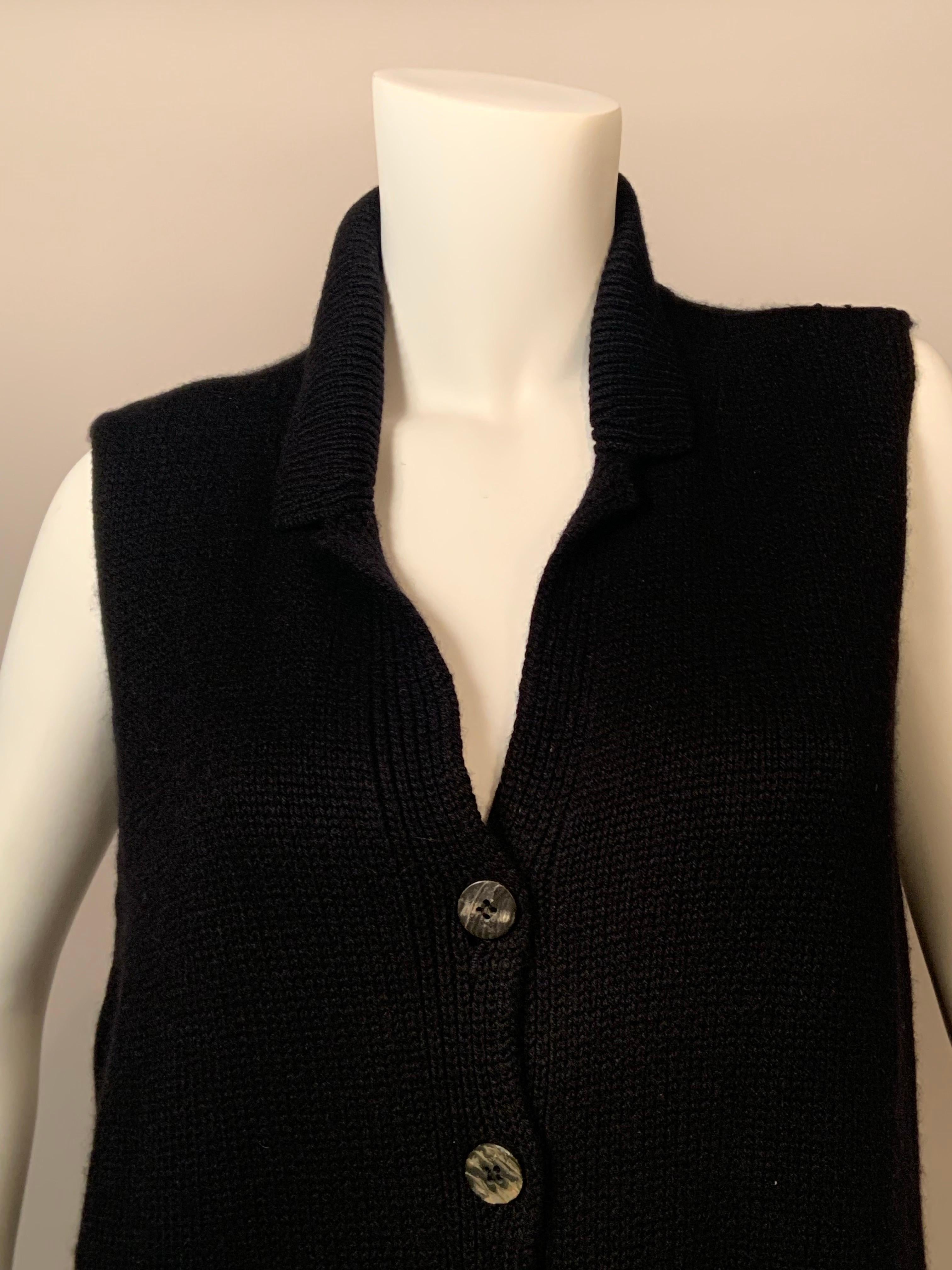 This luxuriously thick black cashmere sweater vest from Brunello Cucinelli is perfect to wear alone in cool weather or for layering when the cold weather arrives.  It has a notched collar, five Mother of Pearl buttons with a spare sewn inside, and