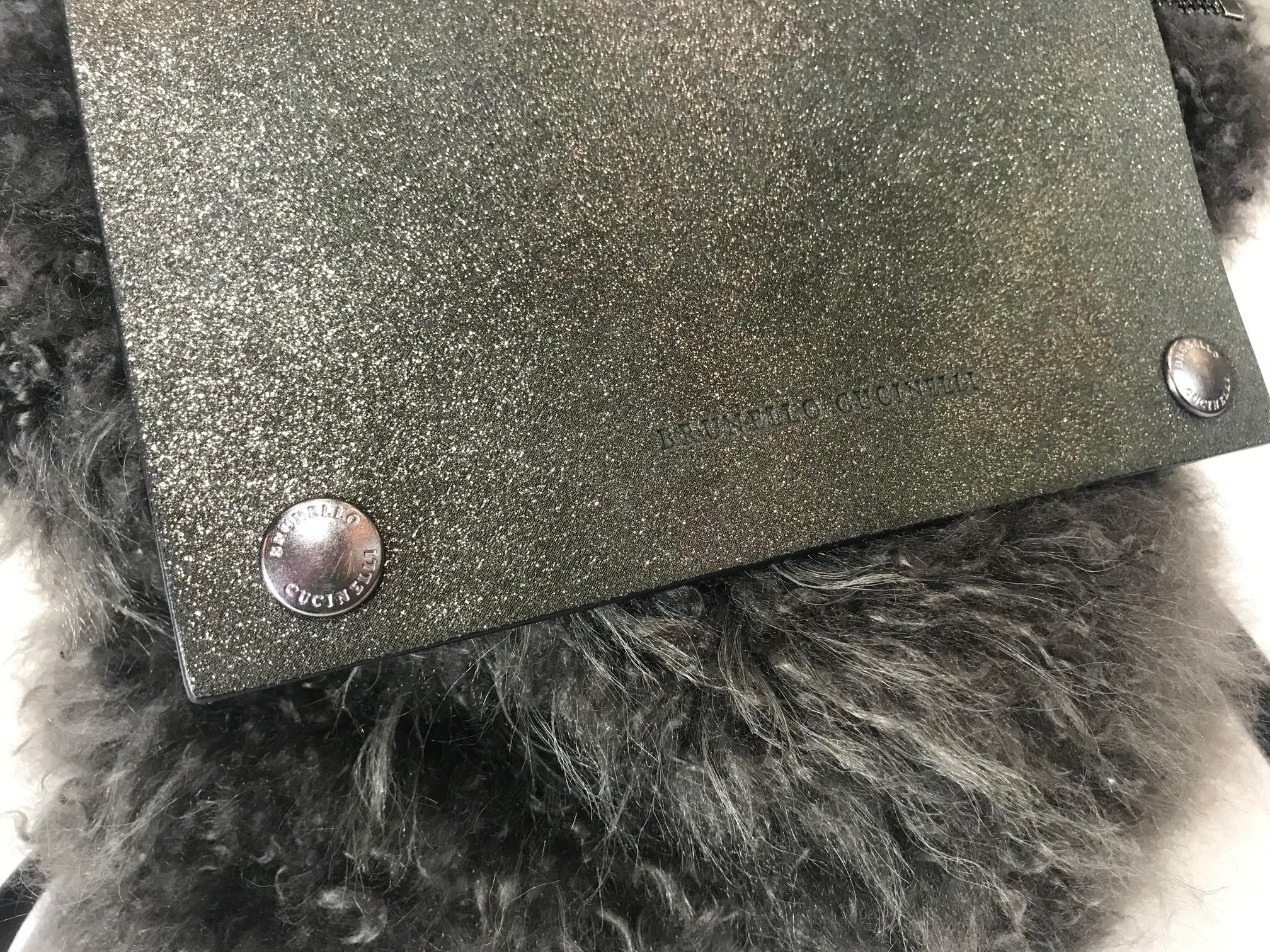 Grey shearling. Silver-tone hardware. Zip closure at top with additional snap closures at front flap. Tonal metallic suede trim. Single flat shoulder strap. Zip pocket at exterior back. Tonal suede interior.