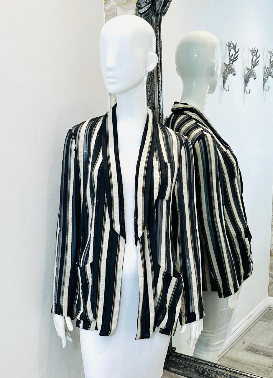 Brunello Cucinelli Sheer Striped Silk Jacket

Black and white loose-fit, open jacket detailed with vertical striped pattern.

Styled with tiny black and silver bead and sheer insert embellishments.

Featuring shawl-collar and three pocket