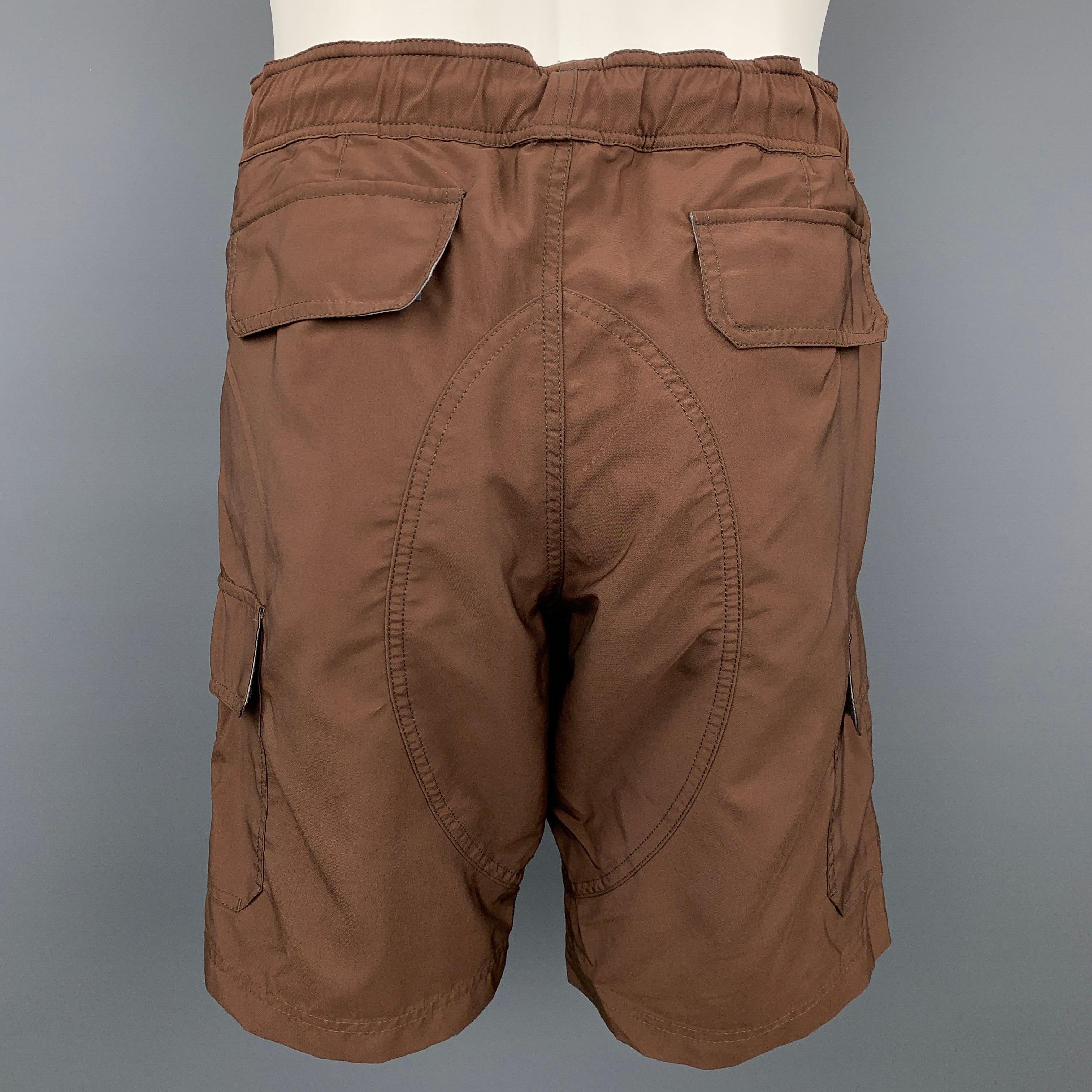 BRUNELLO CUCINELLI shorts comes in a brown polyester with a mesh liner featuring a cargo pockets, drawstring, zip fly, and a snap button closure. Made in Italy.

New With Tags.
Marked: 50
Original Retail Price: $725.00

Measurements:

Waist: 34