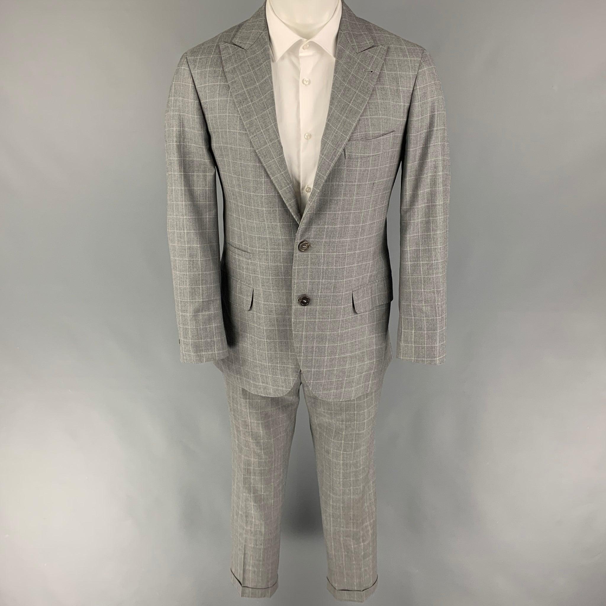 BRUNELLO CUCINELLI
suit comes in a gray window pane lane wool / silk with a half liner and includes a single breasted, three button sport coat with a peak lapel and matching flat front trousers. Includes garment bag & tags. Made in Italy. Good