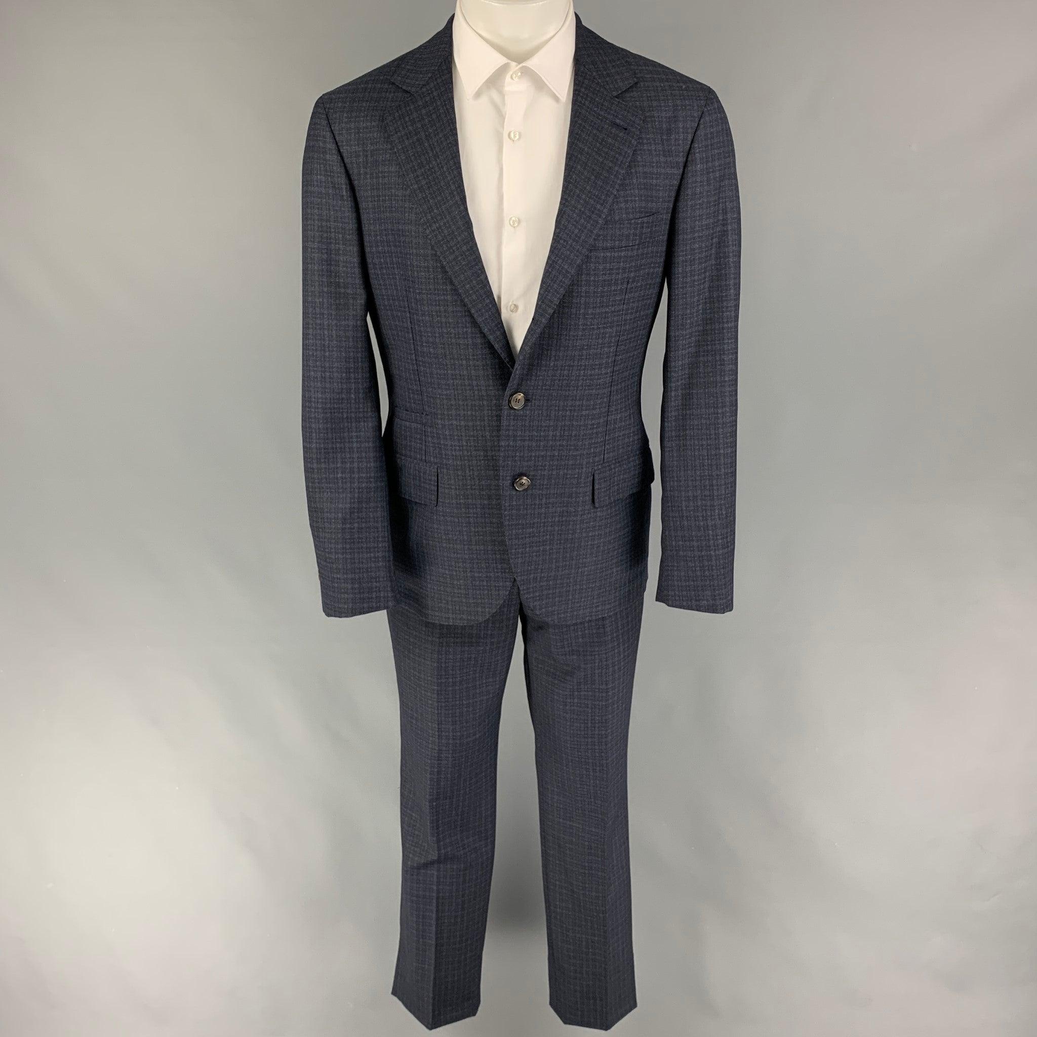 BRUNELLO CUCINELLI suit comes in a navy mouline check print lana wool with a half liner and includes a single breasted, three button sport coat with a notch lapel and matching flat front trousers. Includes garment bag. Made in Italy. New with tags. 