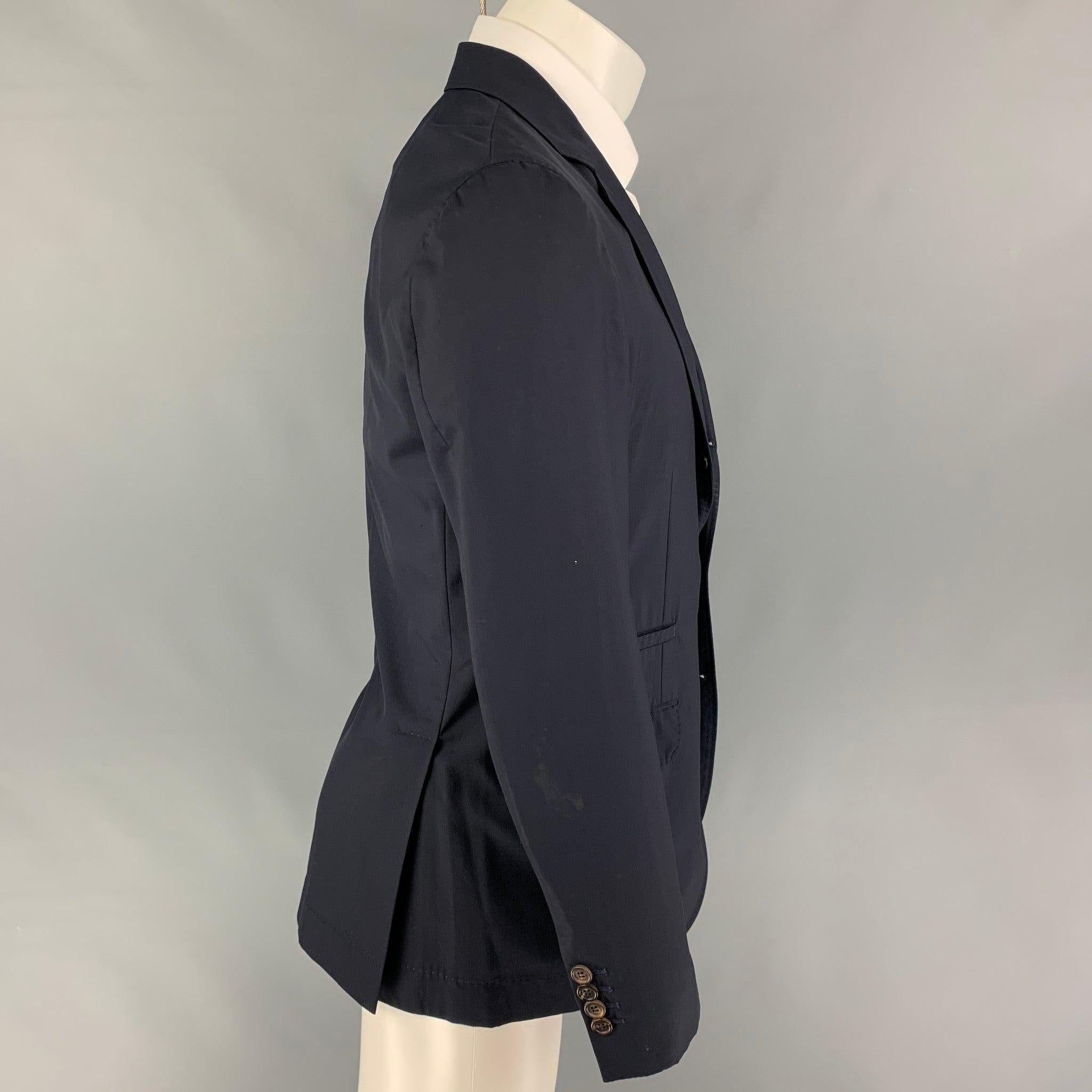 BRUNELLO CUCINELLI sport coat comes in a navy virgin wool / silk featuring a notch lapel, flap pockets, double back vent, and a three button closure. Includes garment bag. Made in Italy.
Good Pre-Owned Condition. Missing button, cuff altered, and
