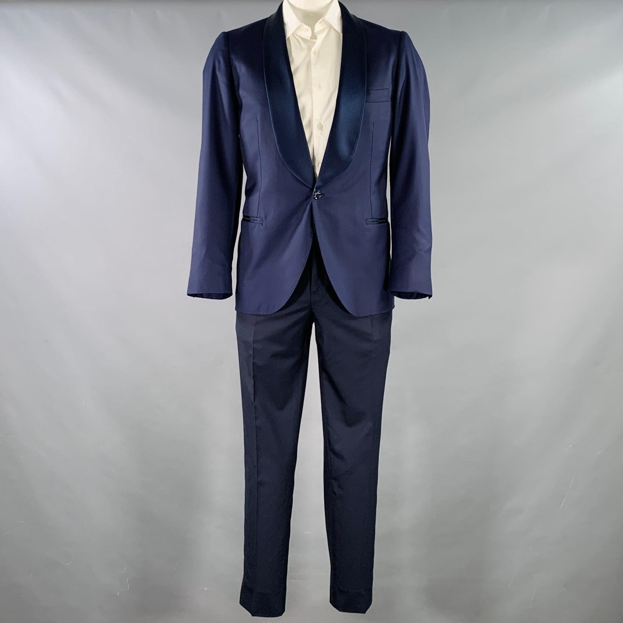 BRUNELLO CUCINELLI tuxedo
in a two toned navy and blue virgin wool silk blend fabric with full liner and includes a single breasted single button sport coat with a shawl lapel and matching flat front trousers. Made in Italy.Very Good Pre-Owned