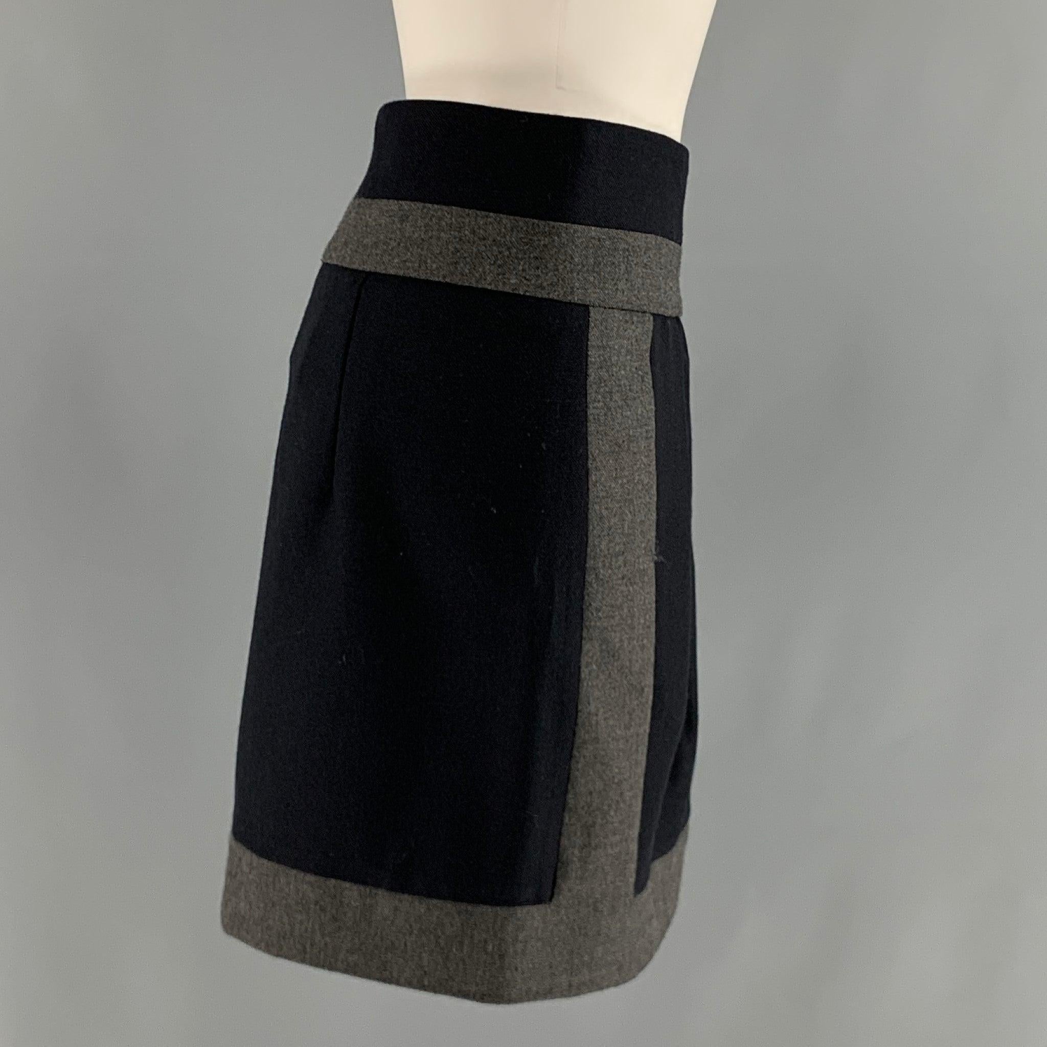 La jupe BRUNELLO CUCINELLI est réalisée dans une matière tissée en laine marine et grise et présente une
 style color block, devant plissé, et style crayon. Fabriqué en Italie. Excellent état. 

Marqué :   6 

Mesures : 
  Taille : 34 pouces 