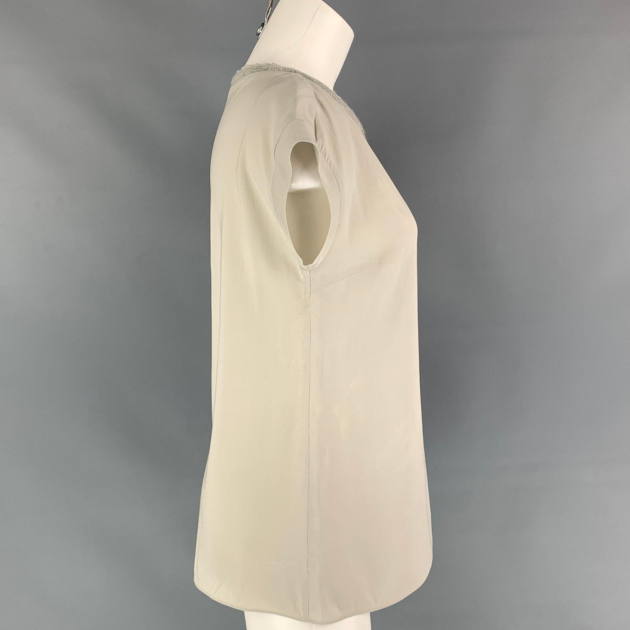 BRUNELLO CUCINELLI blouse comes in a grey rayon blend featuring a sleeveless style, rhinestone details, and a cashmere trim. As-Is. Made in Italy. 

Good Pre-Owned Condition. Moderate discoloration at front & back.
Marked: