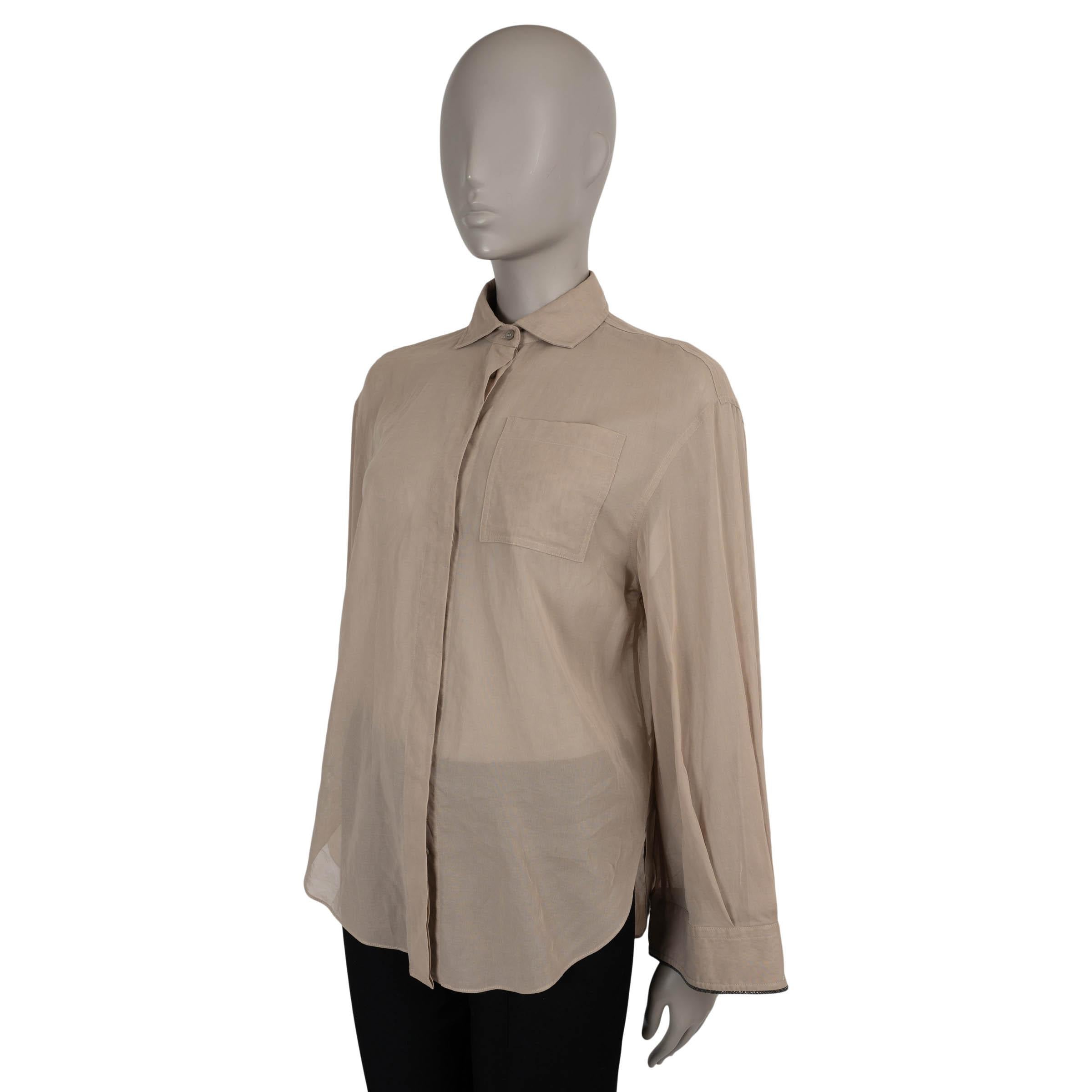 Questa camicia 100% autentica di Brunello Cucinelli in organza di cotone beige sabbia (100%) incarna una sobria eleganza con un tocco contemporaneo. Caratterizzata da una silhouette oversize con spalle scese, è disegnata con un colletto a punta,