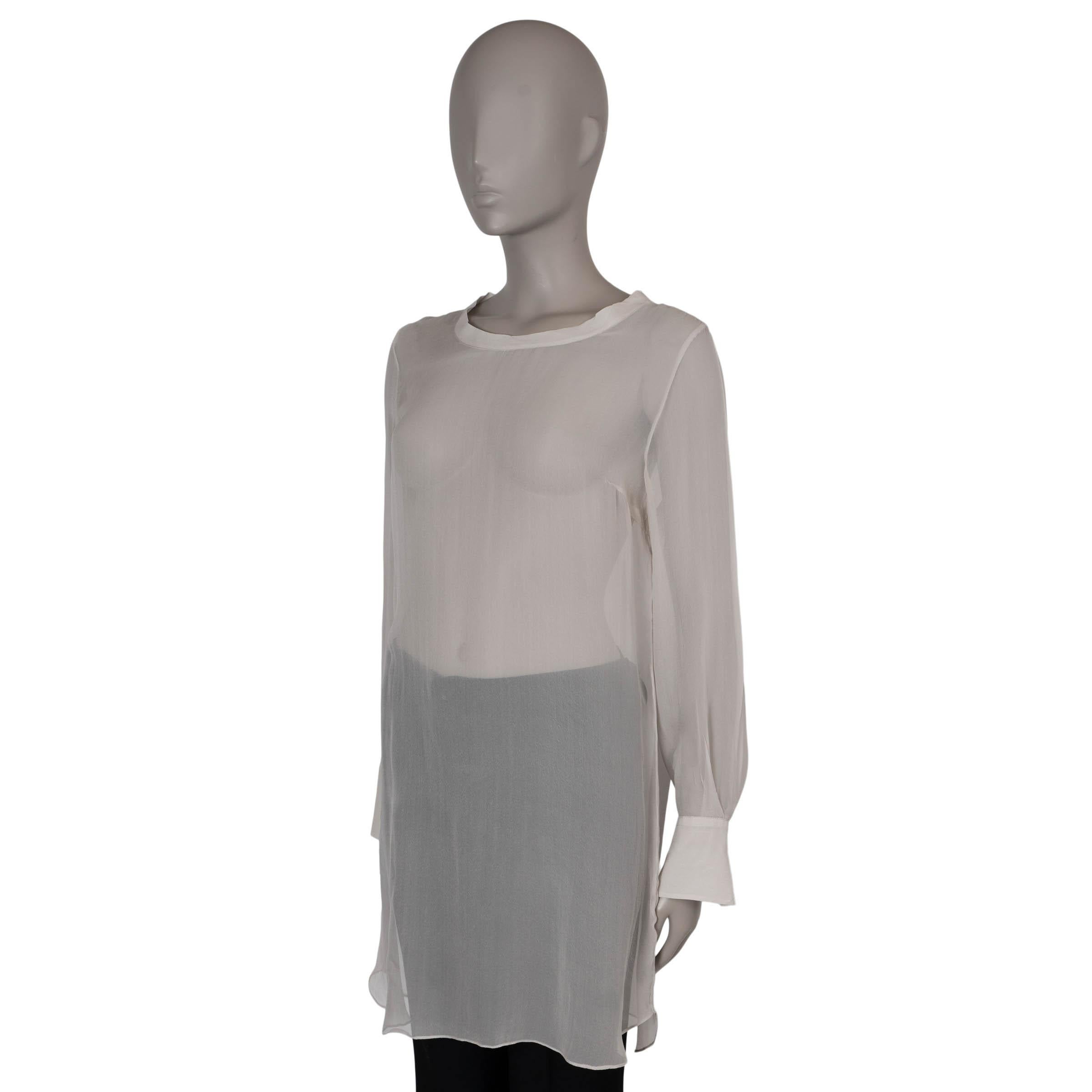 This 100% authentic Brunello Cucinelli tunic blouse in taupe sheer organza silk exudes effortless elegance. It features a refined boatneck and buttoned cuffs, adding a touch of sophistication to its airy design. The blouse closes with a single