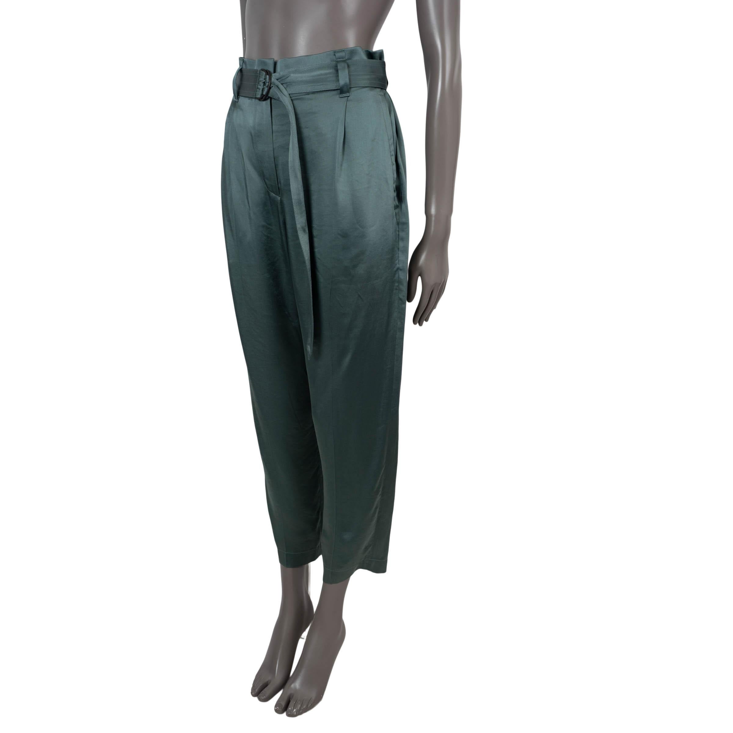100% authentic Brunello Cucinelli belted pants in teal satin acetate (60%) and viscose (40%). Feature an elastic high-waist, tapered leg, to side slit pockets at the waist and two slit pockets in the back. Closes with a matching fabric belt and