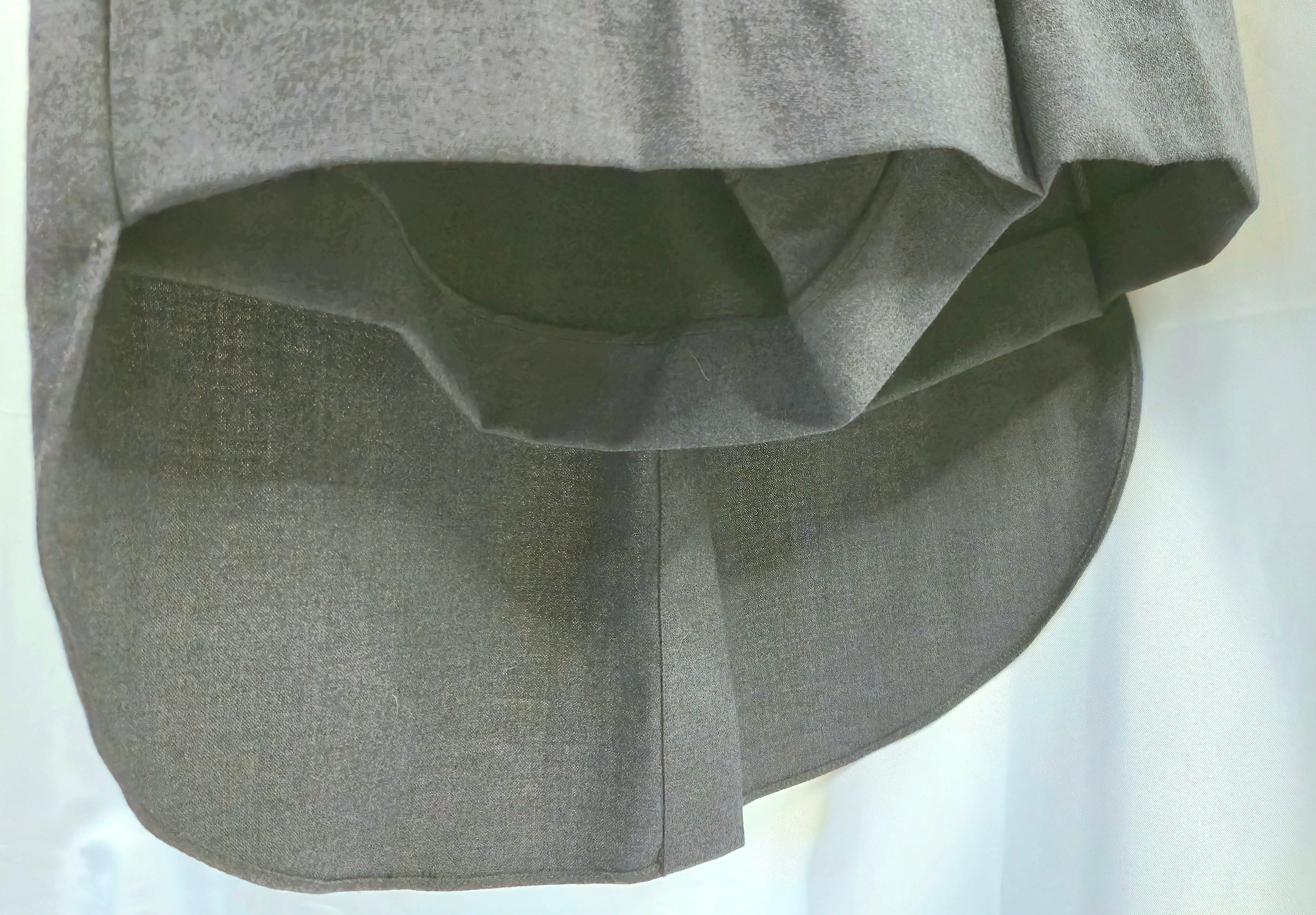 About a decade ago Brunello Cucinelli debuted these impeccably-tailored 100%-virgin-wool grey shorts whose back is completely concealed by tuxedo tails fashioned from a curvilinear-cut and center-slit 19.5-inch-long rear train with decorative