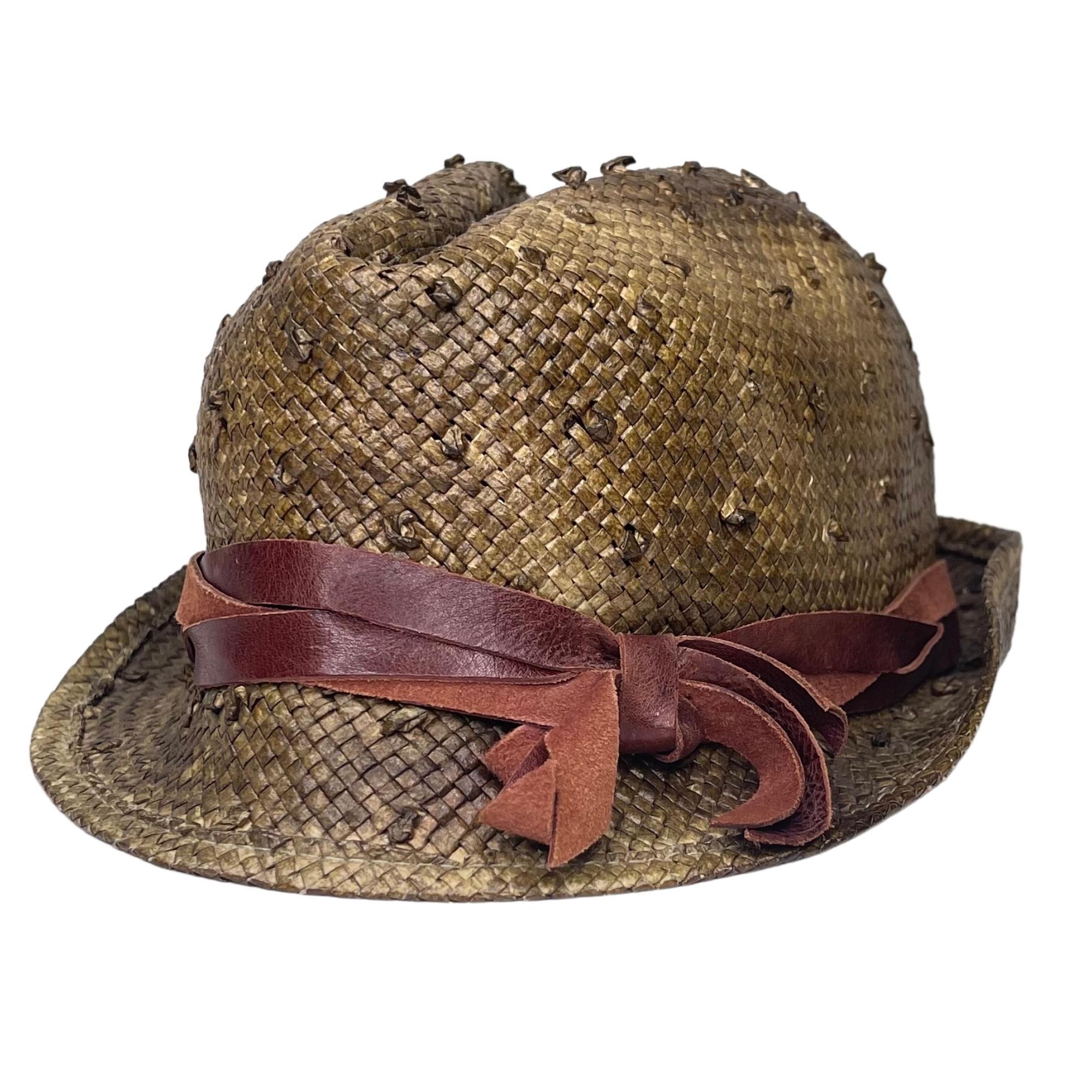 This green hat features marbled shades, woven wicker with a workmanship that resembles ostrich leather and a burgundy band and bow at the top.

COLOR: Green
MATERIAL: Wicker
SIZE: Medium
CONDITION: Good - color fading on the underside of hat, light