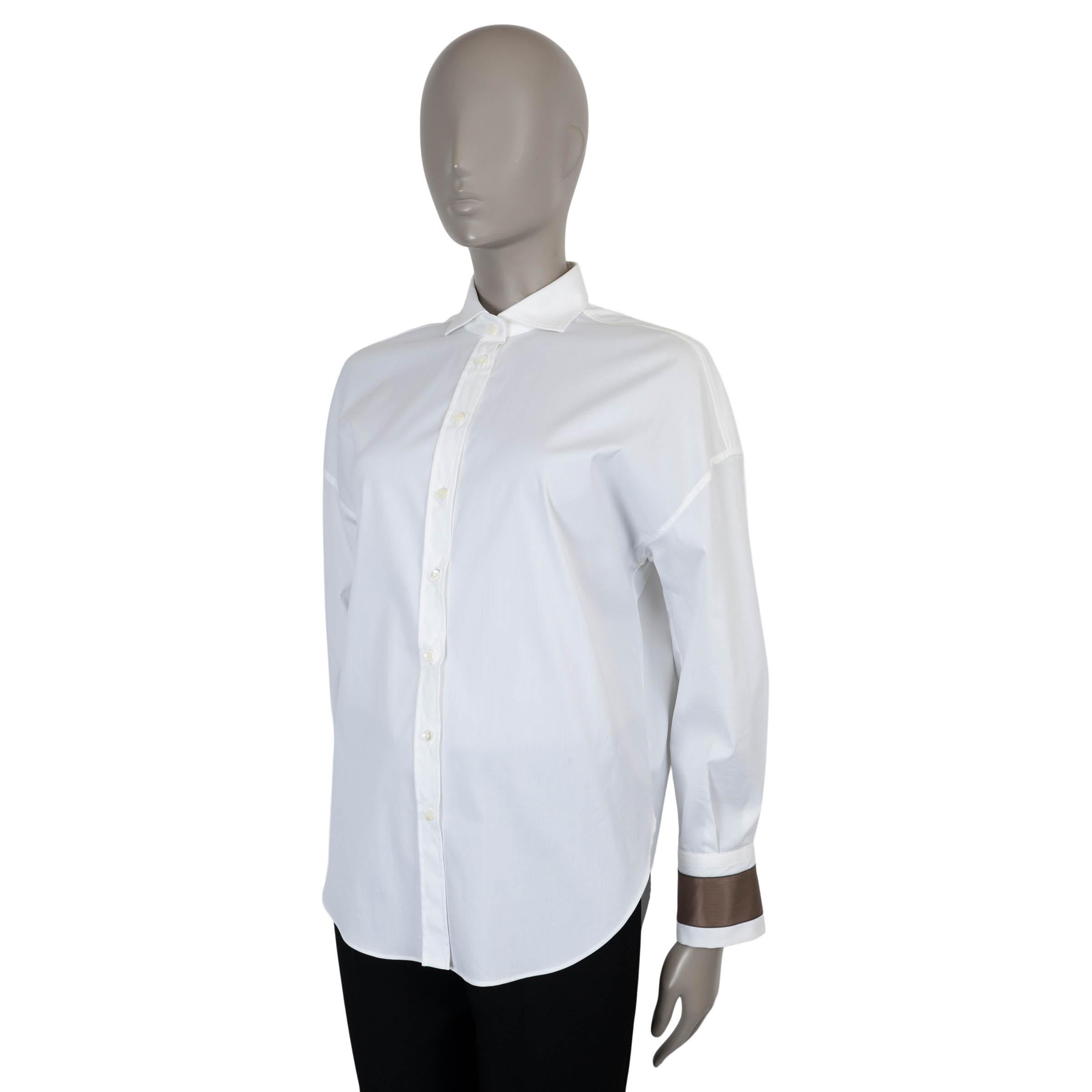 Esta camisa abotonada 100% auténtica de Brunello Cucinelli está confeccionada en popelina blanca elástica de algodón (72%), poliamida (23%) y elastano (5%) para un acabado nítido pero flexible. Presenta una silueta relajada con hombros caídos y