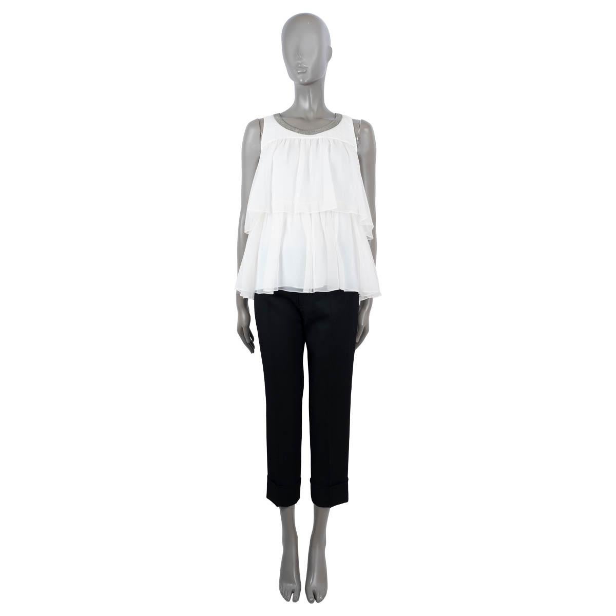 100% authentic Brunello Cucinelli sleeveless top in white silk (100%). Features Monili trim along the neck and two layers of ruffled chiffon. Opens with a concealed button and a self-tie ribbon at the back neck. Unlined. Has been worn and is in