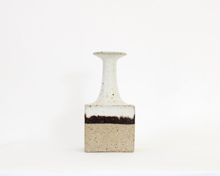 Bruno Gambone decorative ceramic bottle-shaped vessel with chalk-white and tan surface and chocolate glazed ribbon motif by (circa 1970s). With a modern rectangular base and lean, elongated neck its shape and finish have their origins in primitive