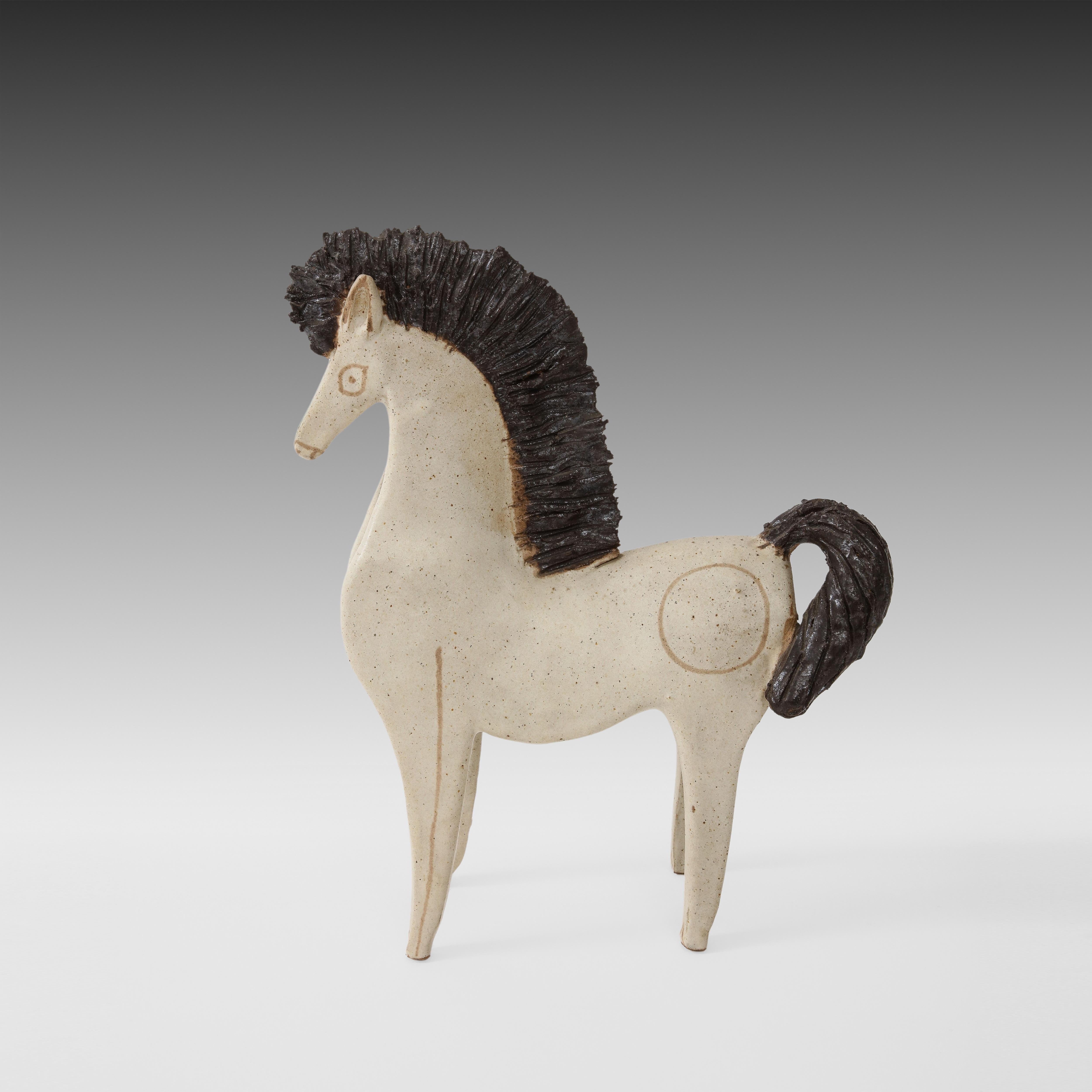 Bruno Gambone large glazed ceramic horse sculpture with flattened hollow body, Italy, 1970s. This regal stoneware horse has an off-white matte glazed body with tan decorations and dark brown mane and tail. 
Signed on underside “GAMBONE ITALY.”